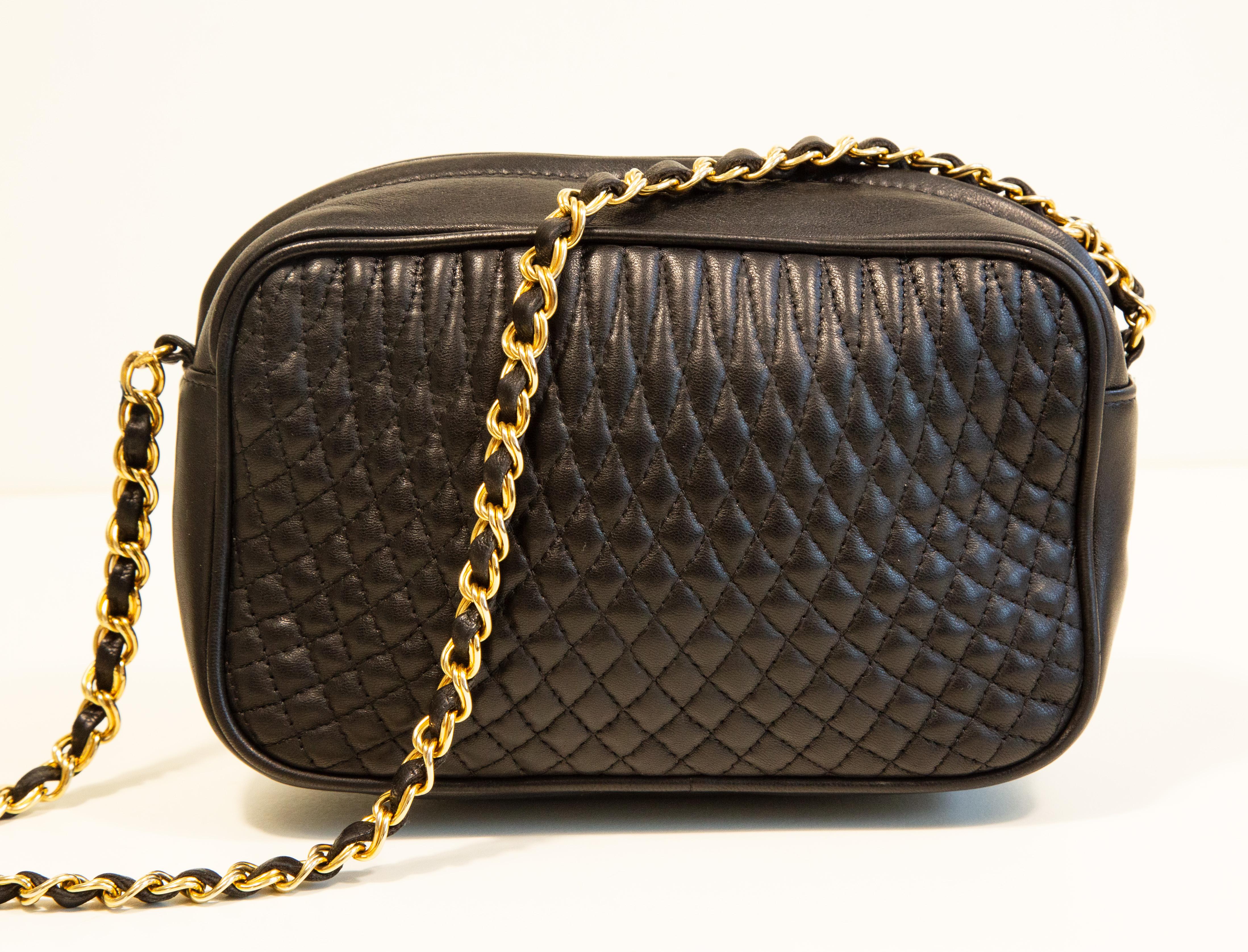 A vintage Bally bag made of black quilted leather with gold toned hardware. The bag features a chain strap intertwisted with black leather, the length of the shoulder strap is: ca 98 cm. The interior is lined with black leather and next to the major
