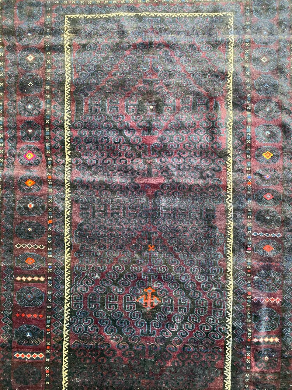 Midcentury Baluch Afghan rug with tribal design and dark colors, entirely hand knotted with wool velvet on wool foundation.