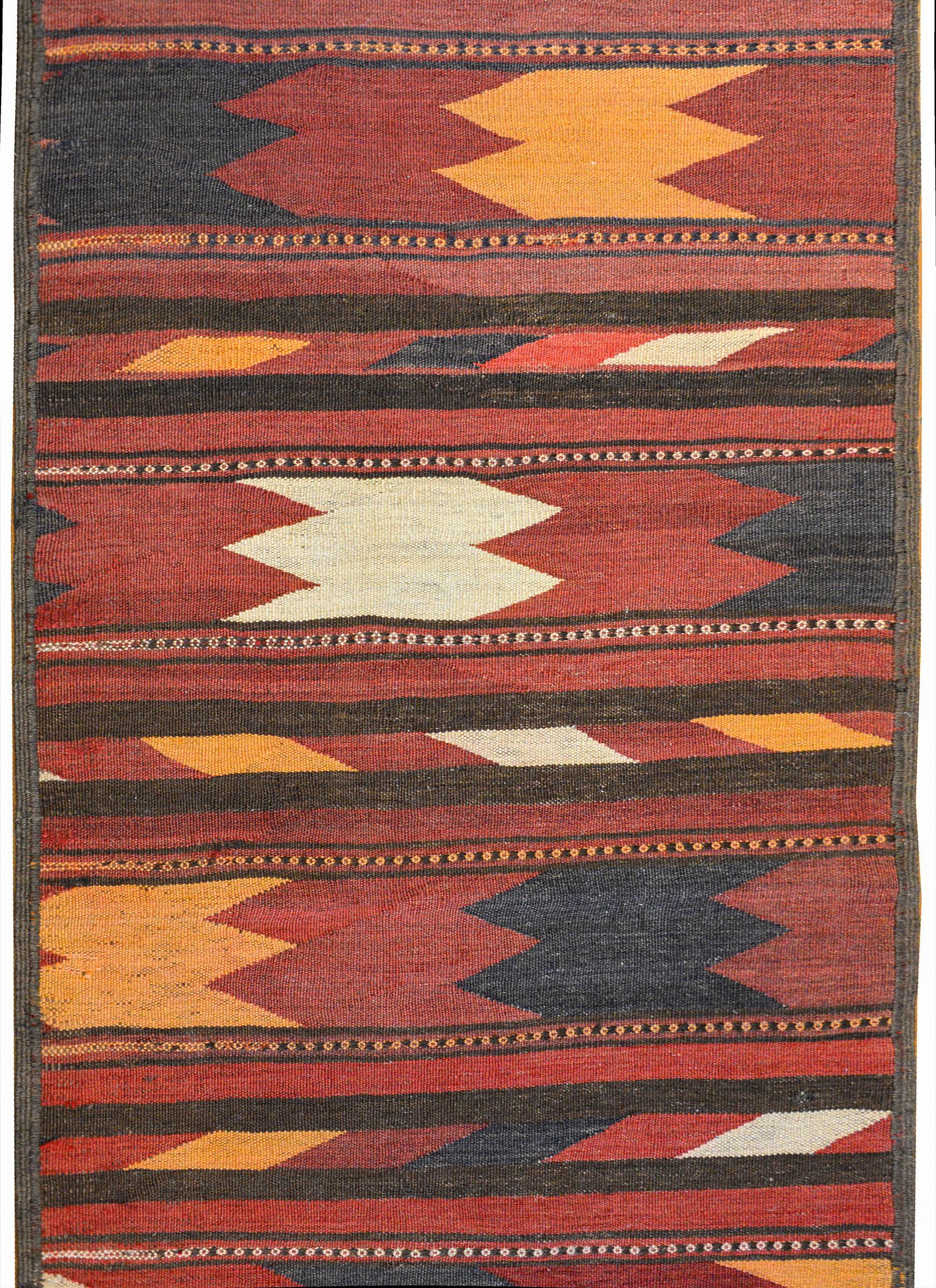 A striking vintage Afghani Baluchi runner with a wonderful bold pattern containing wide alternating zigzag stripes and solid colored stripes.