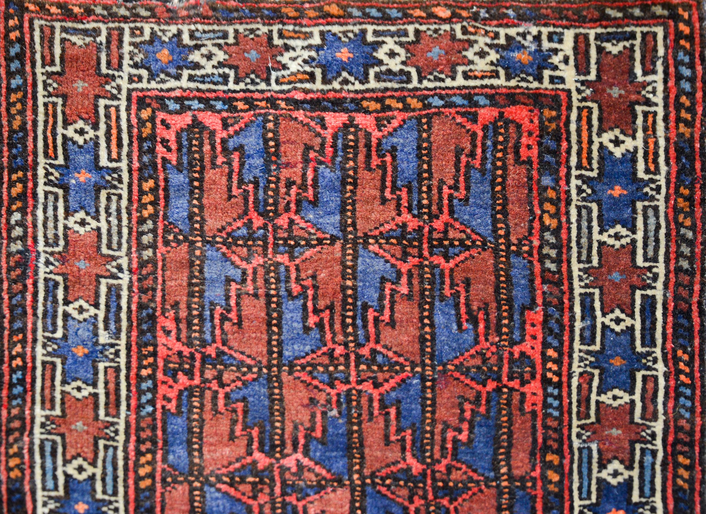 A late 20th century Afghani Baluch runner with one end woven with a stylized leaf pattern woven in crimson and indigo, and the other woven in multi-colored stripes.