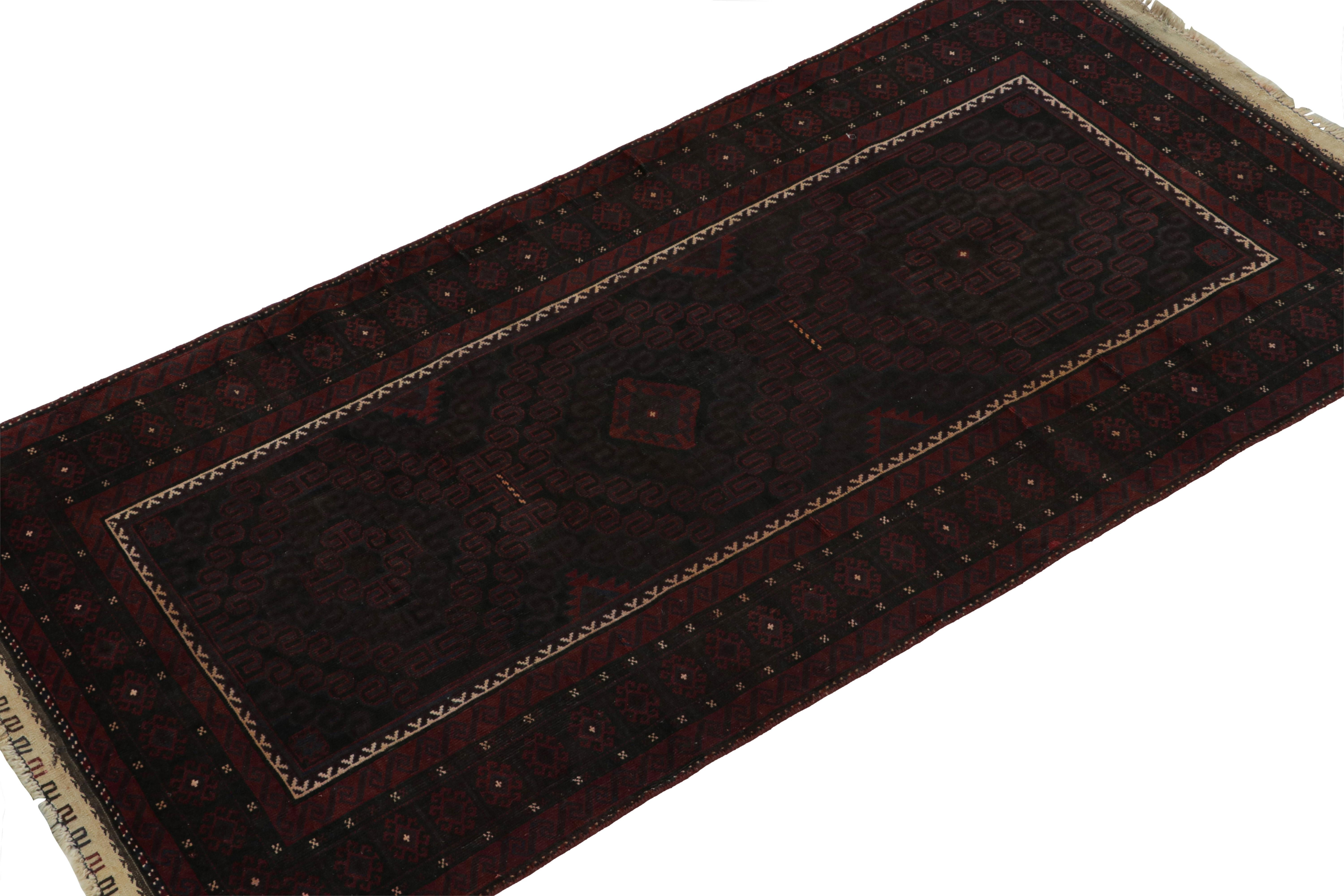 Hand-knotted in wool and goat hair circa 1950-1960, this 3x7 vintage tribal runner is a Baluch rug from new curations in the Rug & Kilim collection.

On the Design: 

This runner rug enjoys rich, saturated colors in maroon and navy blue, with black
