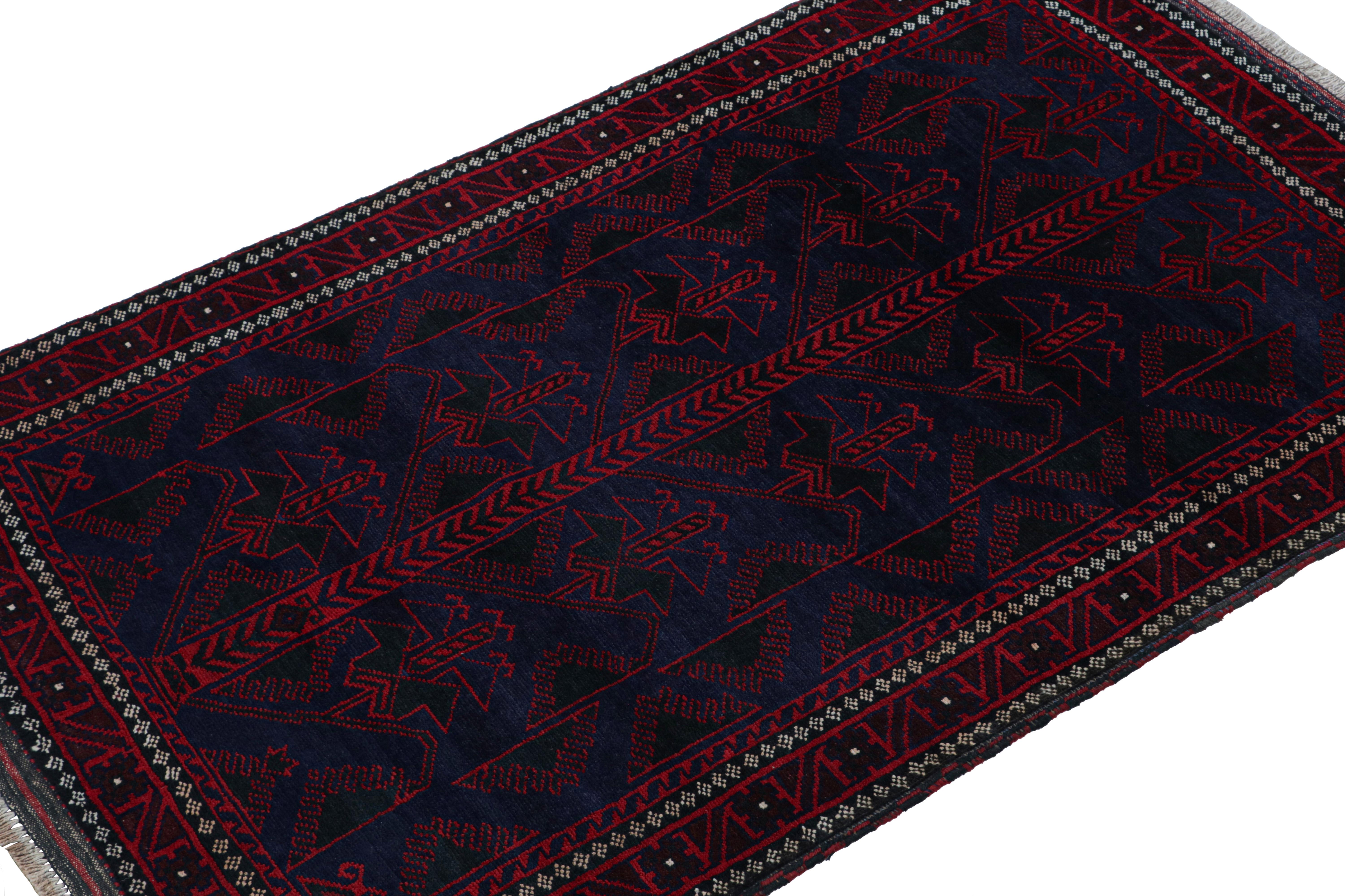 Hand-knotted in wool & goat hair circa 1950-1960, this 4x6 vintage Baluch tribal rug is a new curation from Rug & Kilim. 

On the Design: 

This runner rug boasts geometric patterns in saturated red and navy blue tones. Keen eyes will admire fine