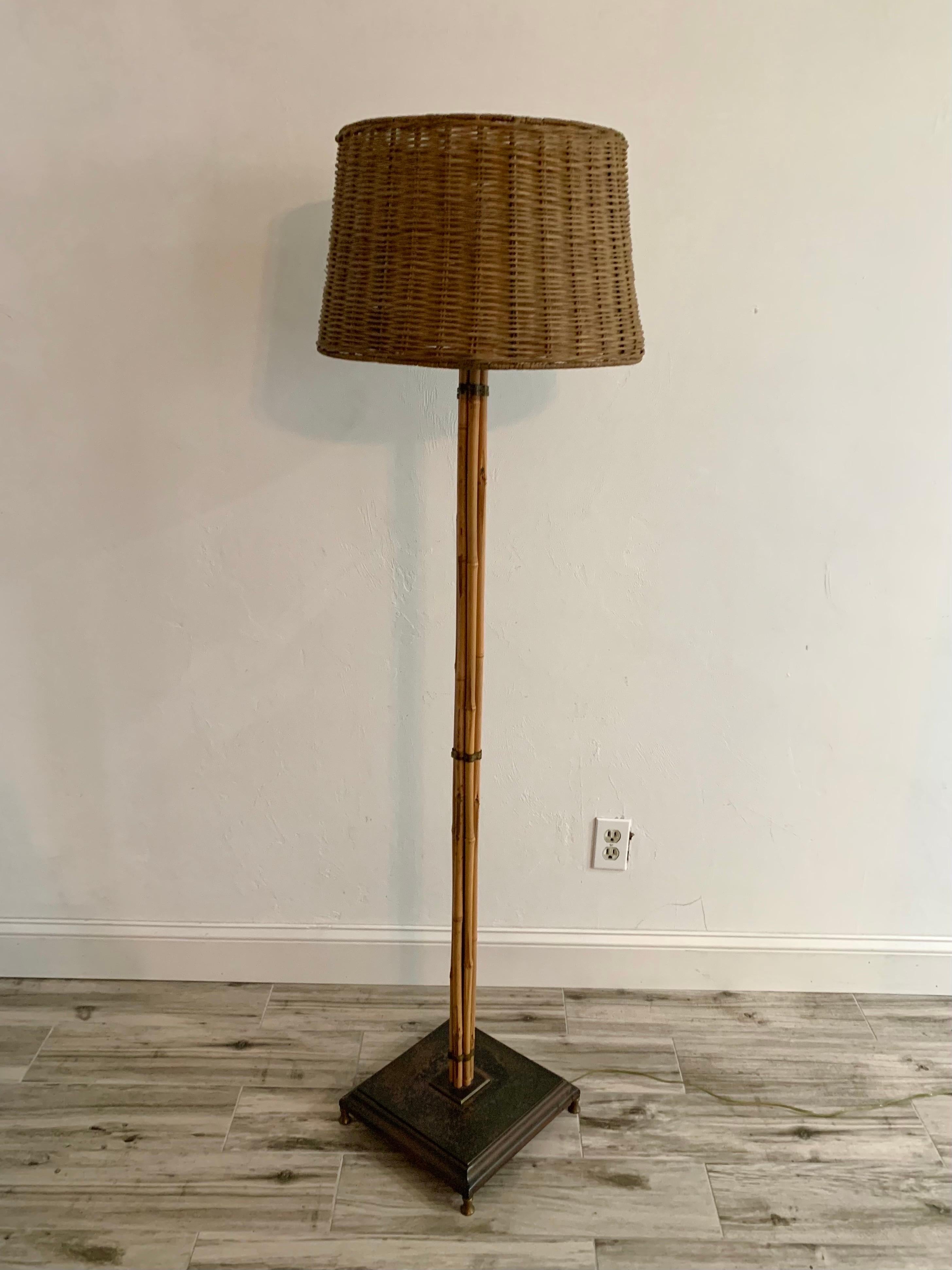 A simple elegant floor lamp by an unknown designer. 1960s-1970s. Bamboo rods fitted perfectly with thick brass straps on a patinated metal base with brass feet. 

Lamp has a three way switch to set a light for any mood you’d like. Wicker shade is