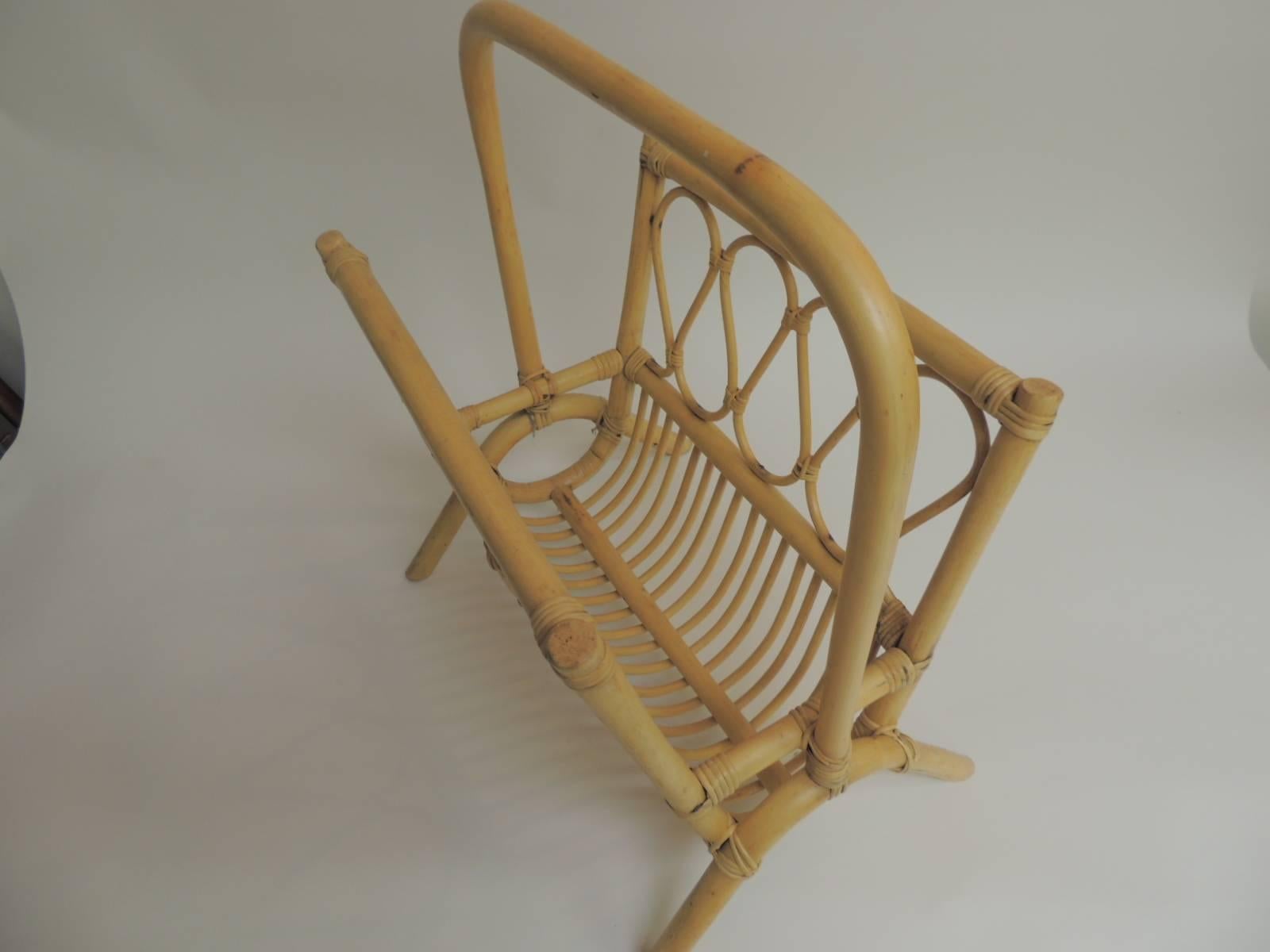 Vintage bamboo and rattan magazine stand. 
Pale color bent bamboo magazine rack with handle and undulating
 trellis pattern design on both sides.
Size: 17 x 10 x 19.

 