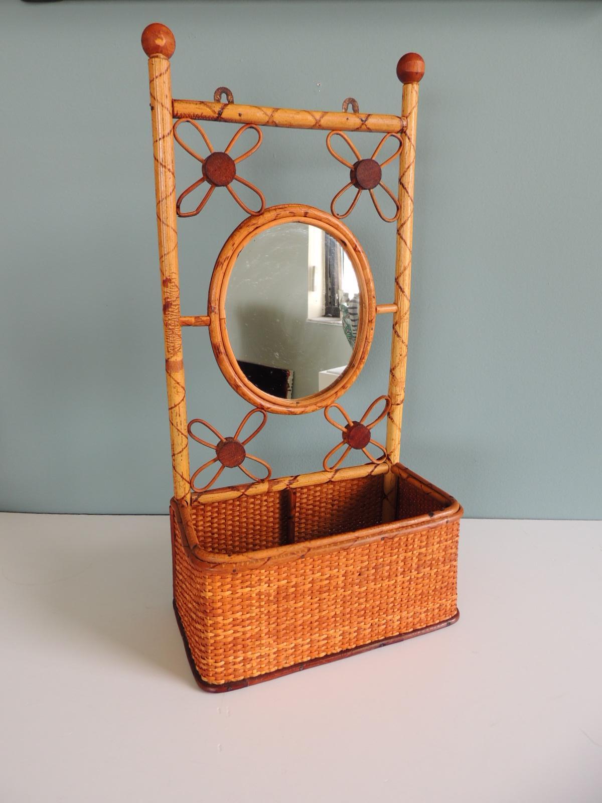 Vintage bamboo and rattan wall shelf
Shelf with basket for mail or keys
Small oval mirror and flowers' details. 
Tortoise surface finish. 
Hanging hooks in the back.
Size: 9.5