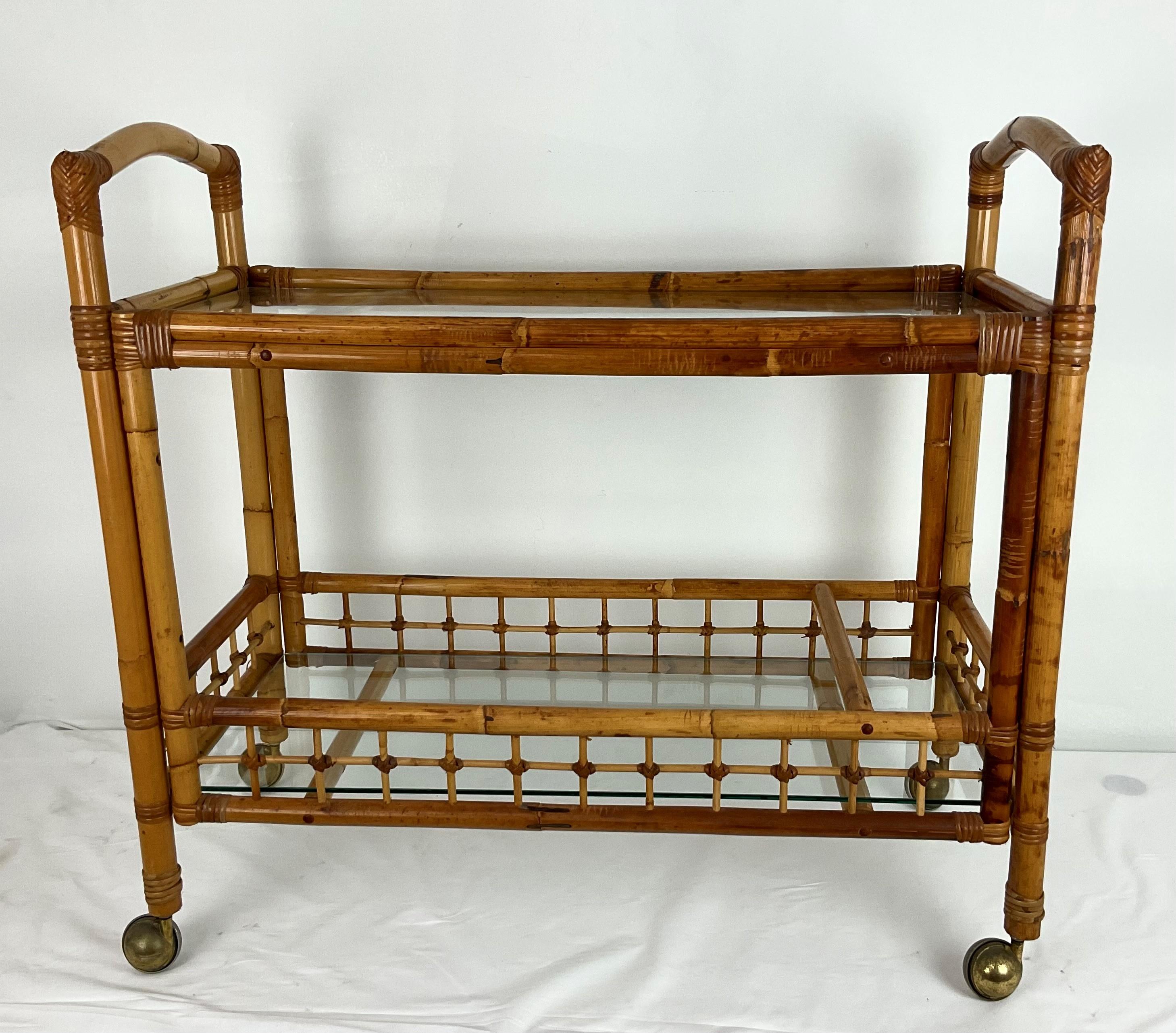 Bellissimo e grande carrello da bar in bambù e vetro fatto a mano con ruote. Le ruote sono originali e appannate ma funzionano perfettamente. Il bambù ha una ricca patina ed è in perfette condizioni. Design semplice e lavorazione di alta qualità.