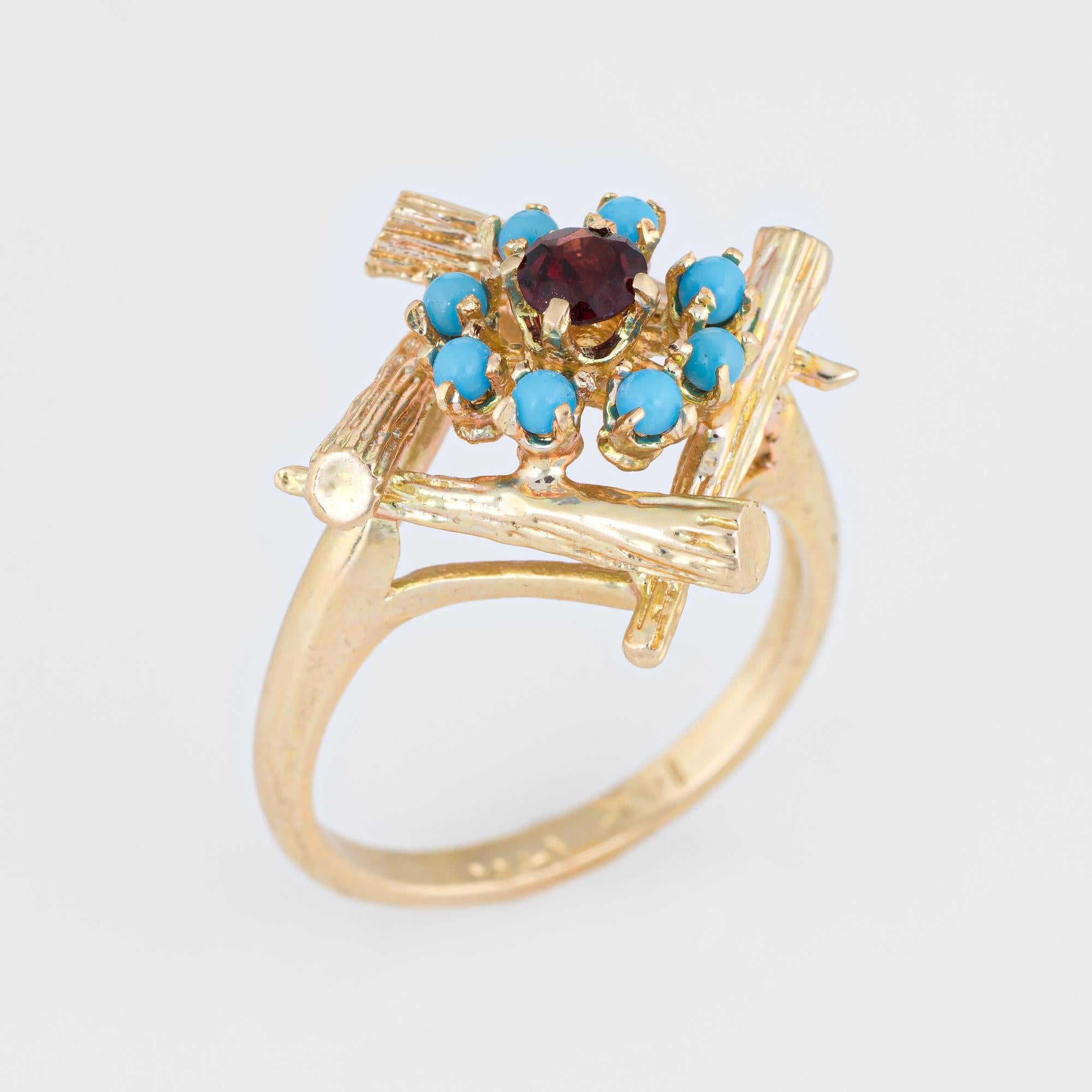 Finely detailed vintage turquoise & garnet cocktail ring (circa 1970s), crafted in 14 karat yellow gold. 

Centrally mounted garnet is estimated at 0.20 carats, accented with eight 2mm pieces of turquoise. The turquoise & garnet is in excellent