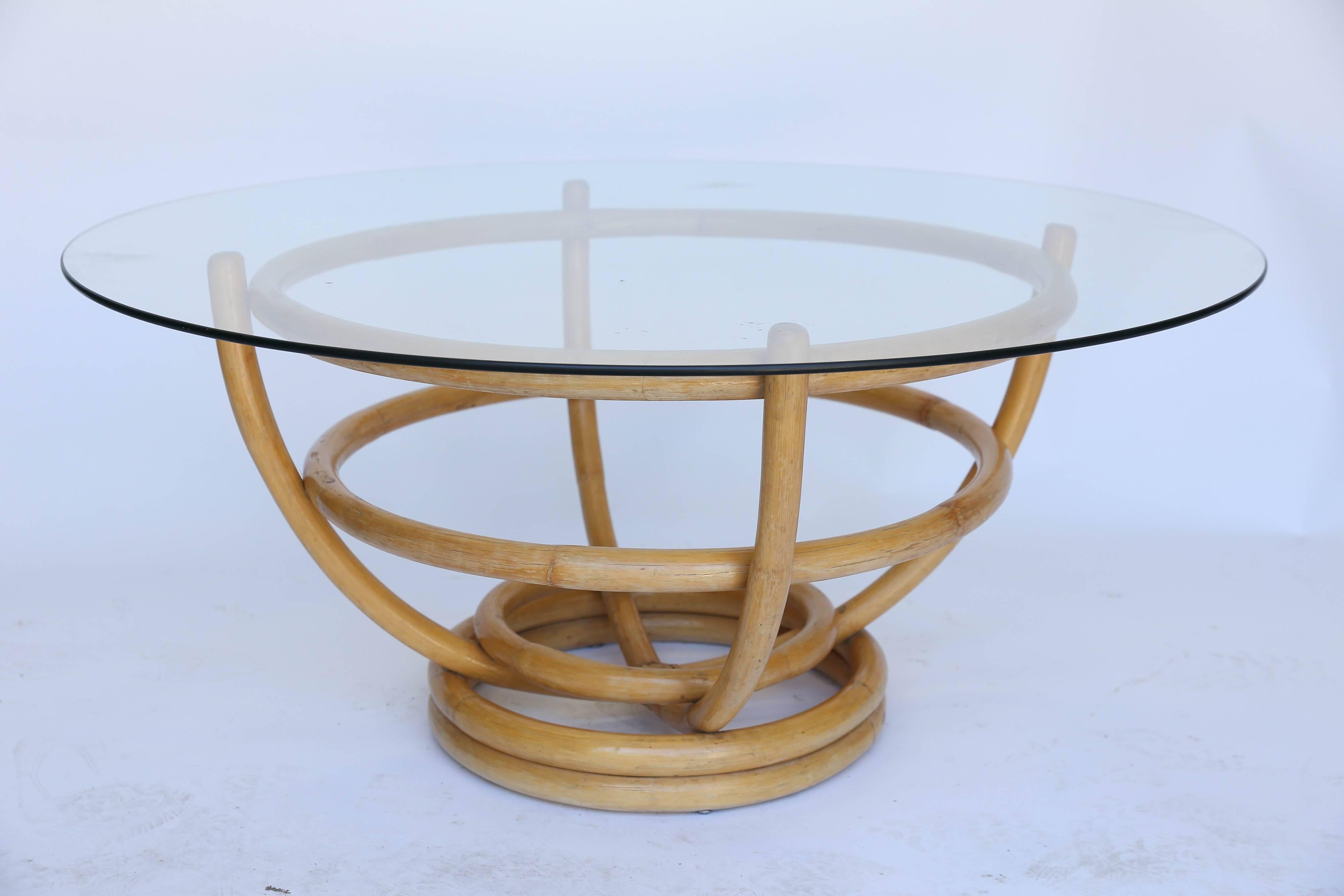 In nearly perfect condition, a round midcentury bamboo coffee table with glass top. With no splits or tears in the bamboo wrapping, this is retro cool at it's best.