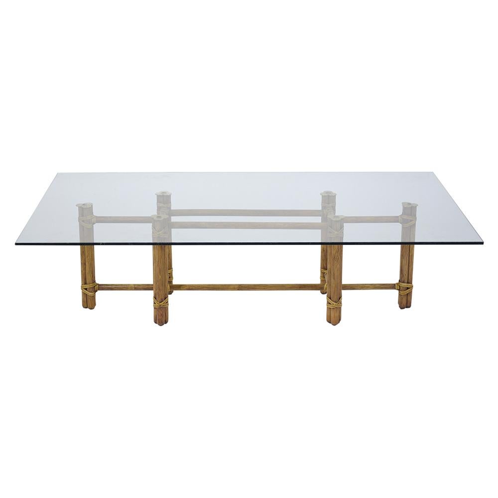 A unique vintage bamboo coffee table is handcrafted out of bamboo and has been fully restored by our team of craftsmen. This table features a new 3/8 clear glass with a flat polished edge, the top is held by stretched bamboo pedestal legs with