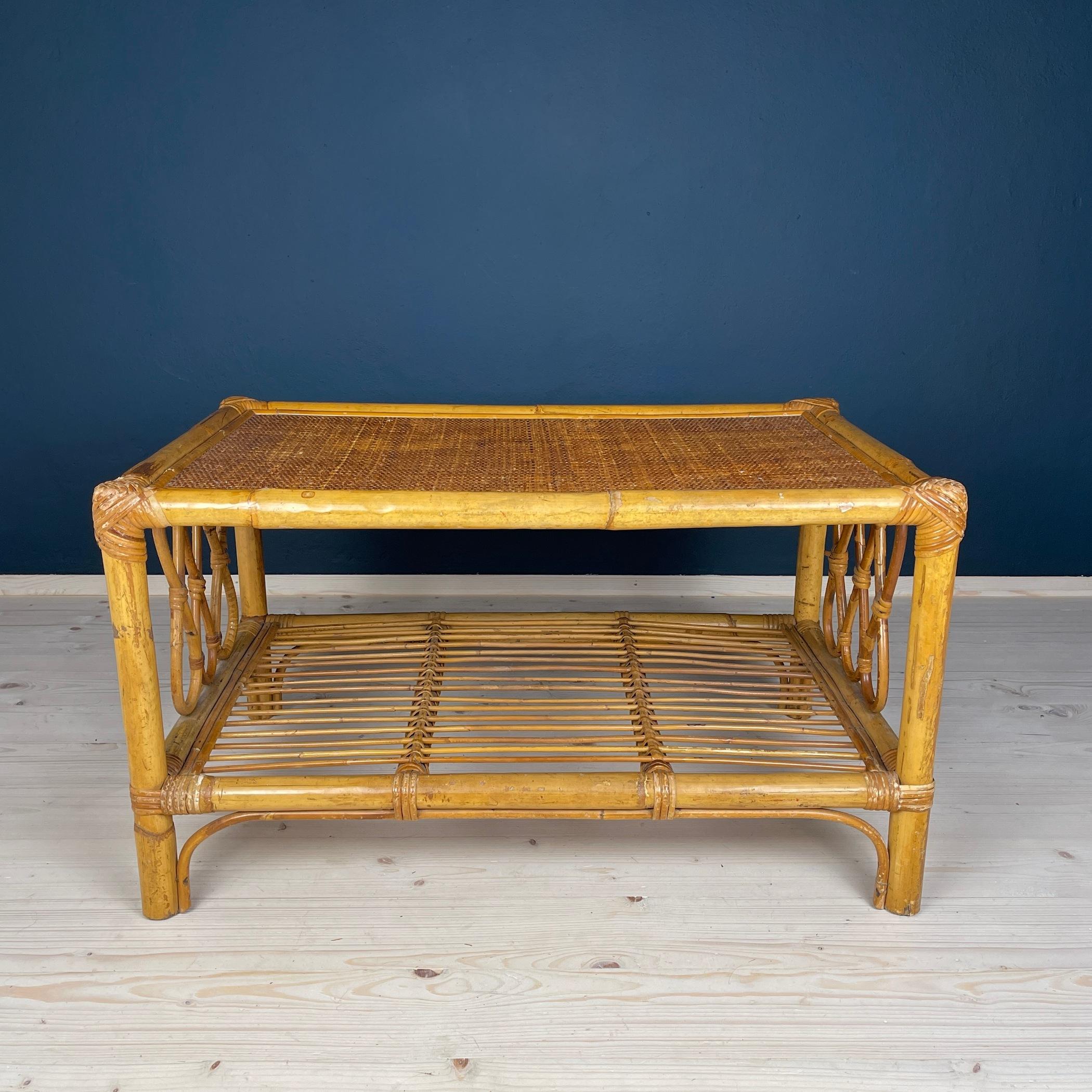Enhance your living space with this exquisite vintage rattan coffee table, hailing from the 1970s and crafted in the heart of Italy. Skillfully made from natural rattan, this table is a testament to its durability and stability, characteristics that