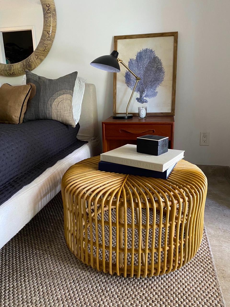 Vintage hand-crafted round bamboo coffee table or ottoman with rattan accents and contemporary Organic Modern design. Rounded form with flat sides features bent bamboo with open slats running in opposite directions, creating a geometric pattern.