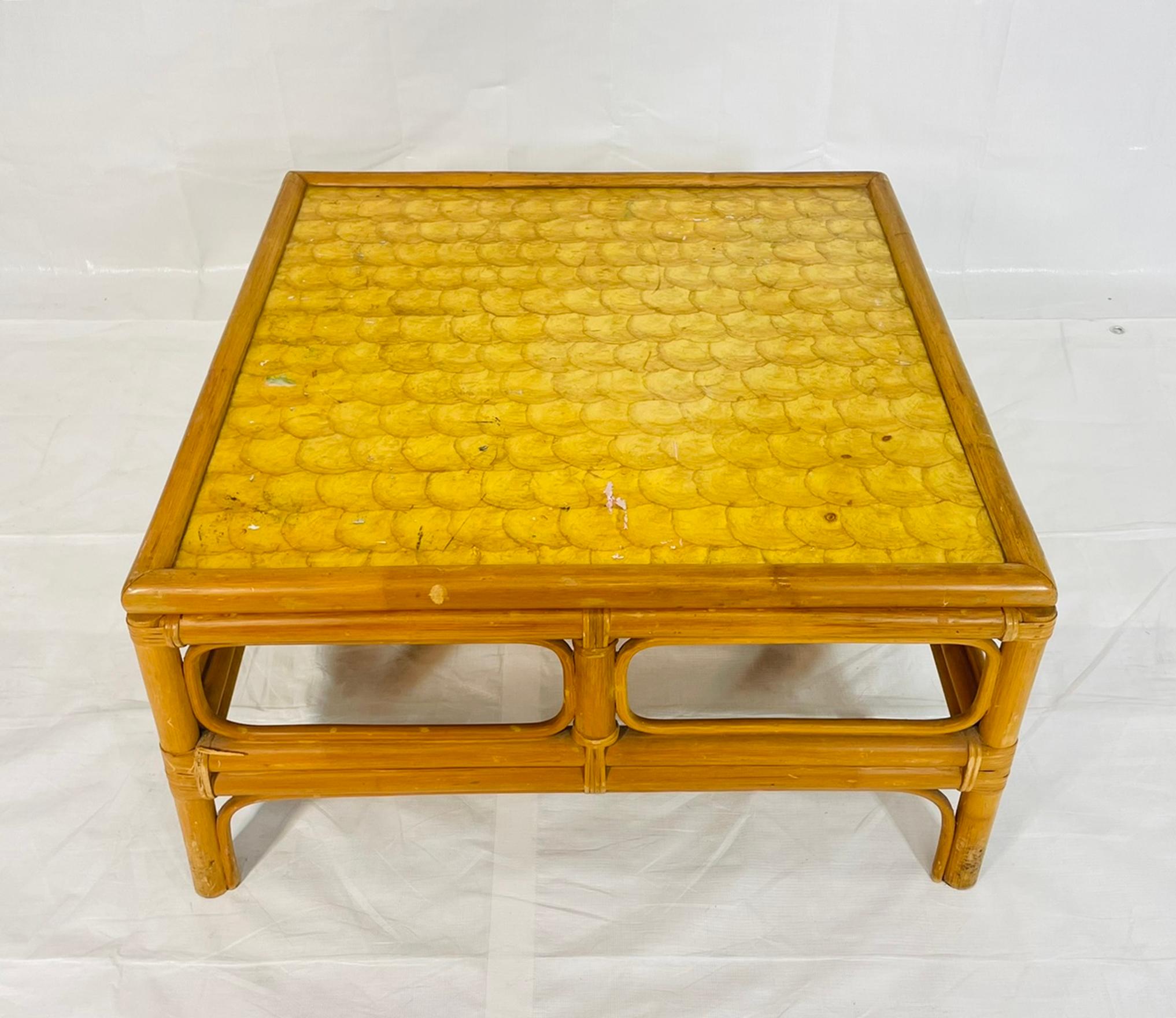 A charming vintage bamboo coffee table featuring a hand-crafted capiz shell inlaid top, dating from the 1970s. This square table showcases the warm organic tones of natural bamboo paired with the iridescent shimmer of capiz shell, creating a look