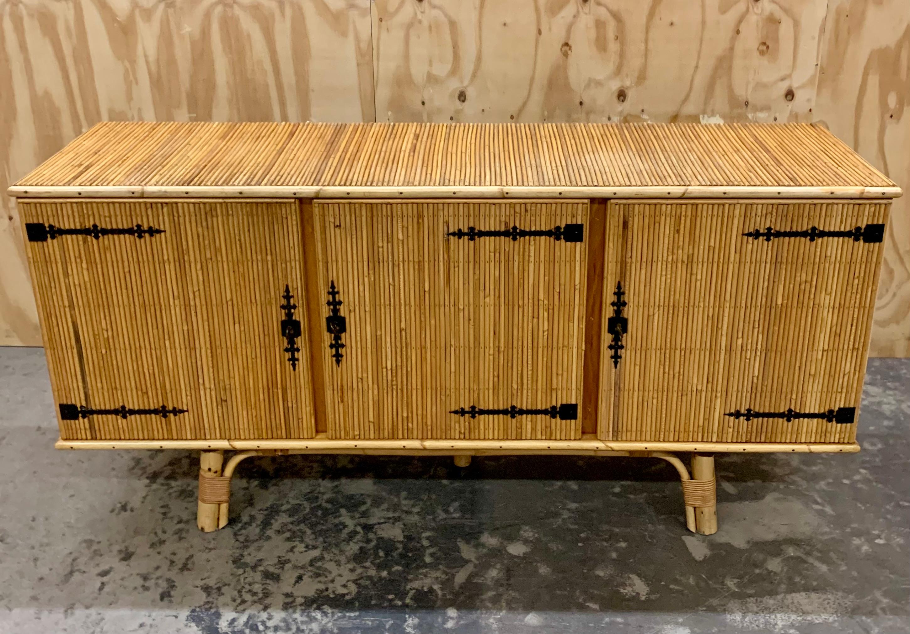 Credenza francese vintage in bambù e rattan degli anni '70. La credenza è elegantemente sollevata dal pavimento su robuste gambe di bambù e dietro le 3 ante si nascondono tre vani di cui due con ripiano. Il buffet è in ottime condizioni - aggiungerà