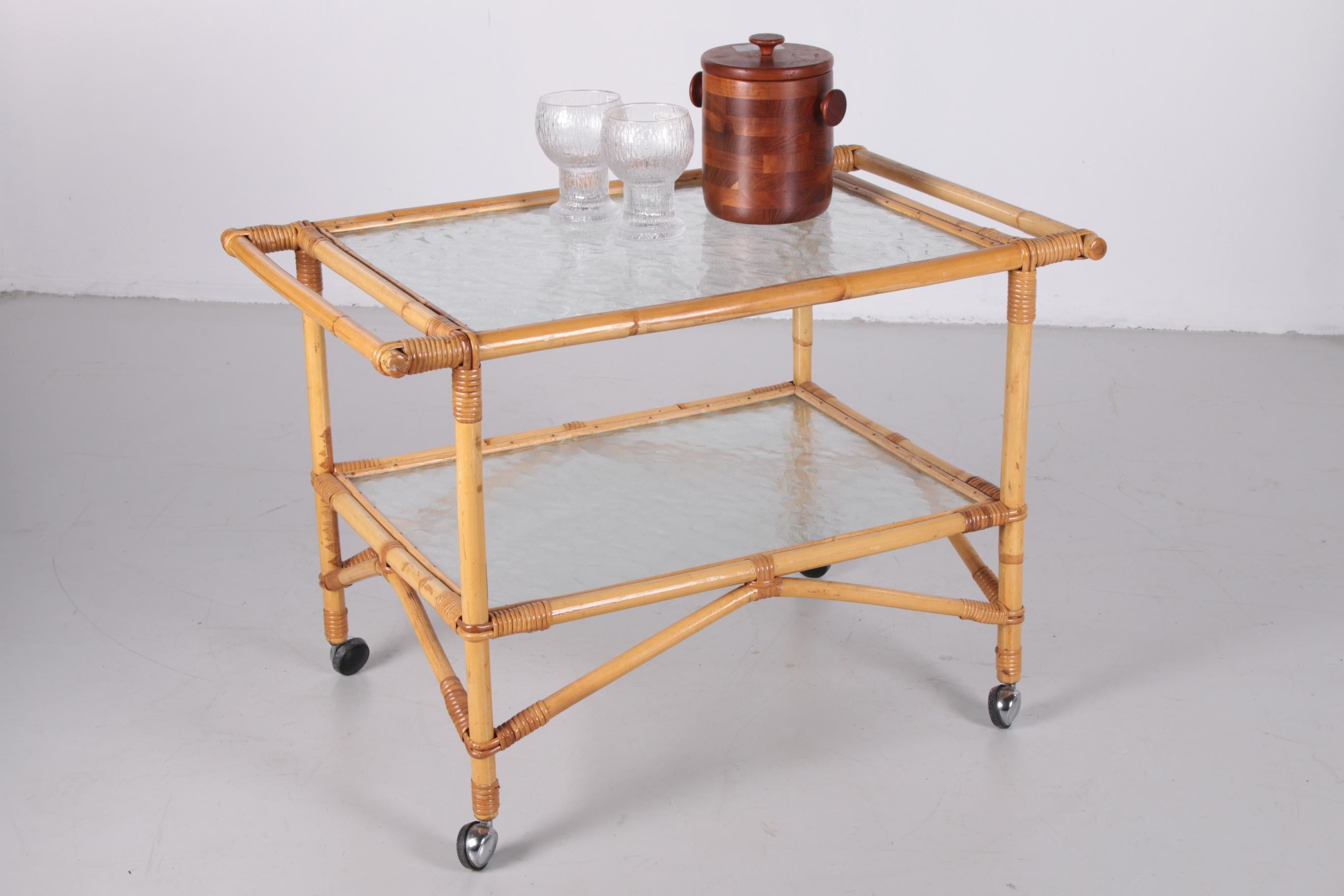 This beautiful vintage rattan/bamboo drinks trolley is typical of the 60s and combines perfectly with both vintage and new interiors. This trolley is originally from Denmark. The trolley has a rectangular shape with two levels. The bottom is ideal