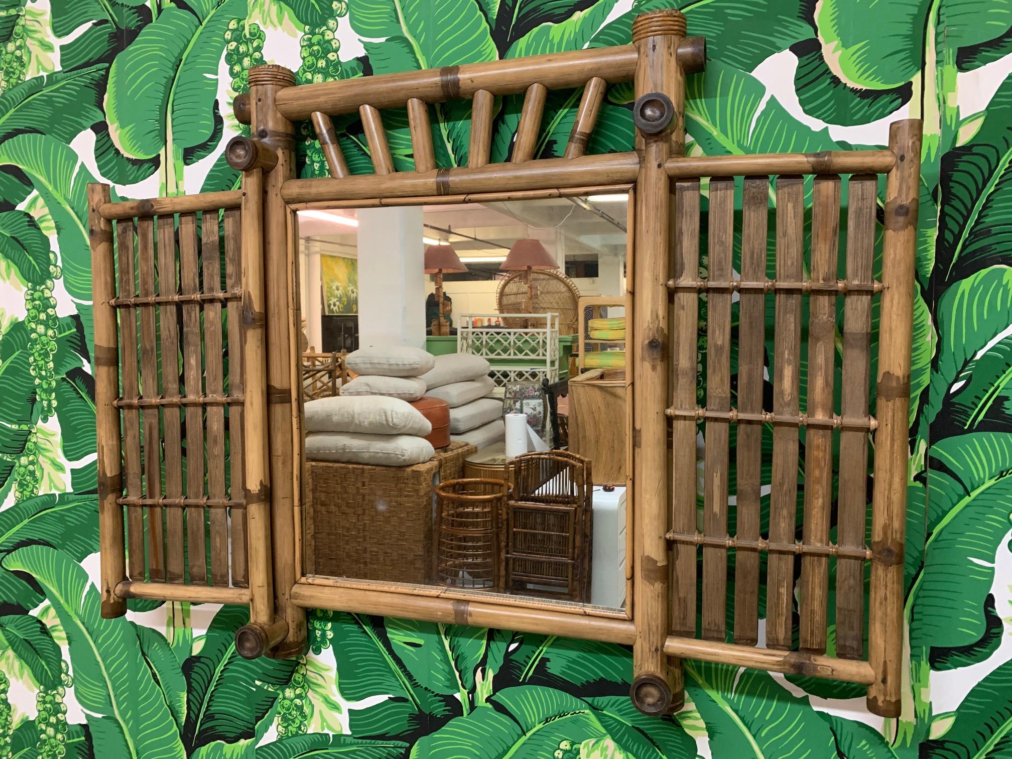 Tiki style bamboo and rattan mirror features double door sides that can swing closed to hide the mirror. Mirror can be mounted on the wall or it can stand on a dresser or desk as a vanity mirror. A perfect way to add some Polynesian island style to