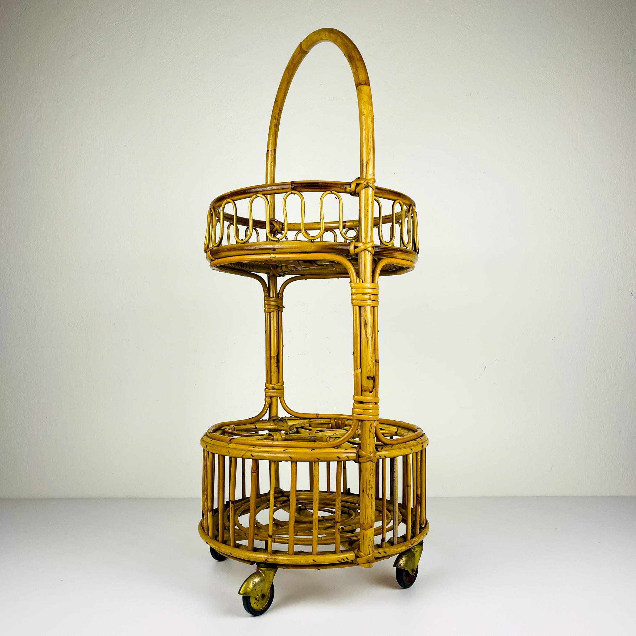 

Incredibile carrello da bar in rattan e bambù realizzato in Italia negli anni '60.
Il livello inferiore è pensato per riporre le bottiglie, mentre quello superiore è dotato di un'utile maniglia per spostare il carrello.

Il carrello vintage è in