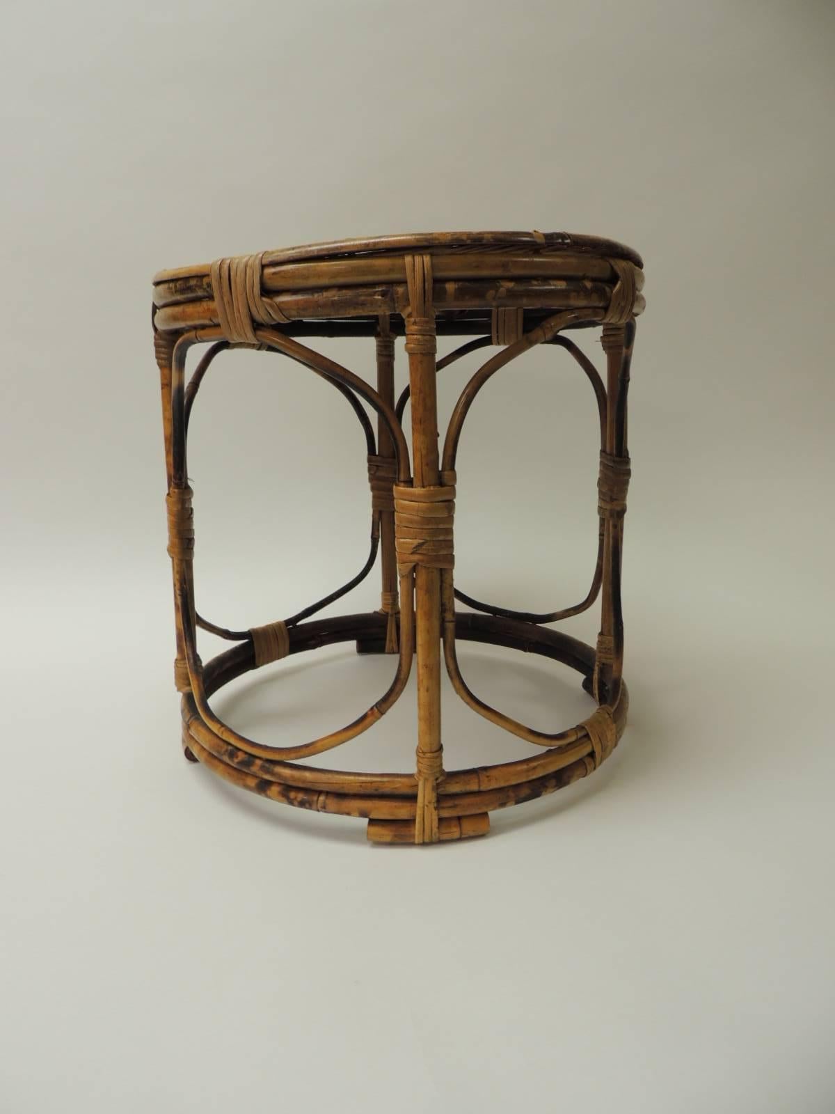 Vintage bamboo round side table
Bamboo vintage round small side table with slatted bamboo top intertwined with rattan and small bamboo feet. Circular bamboo base. Bamboo was burnt to resemble aging. Artisanal style.  Embellished with a faux tortoise