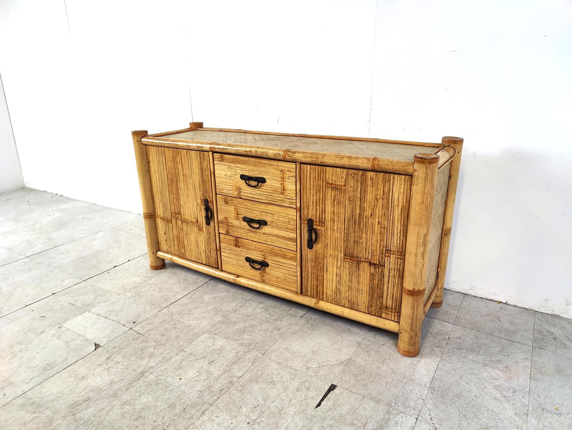 Wabi sabi bamboo sideboard with two doors and 3 central drawers.

Black metal handles.

Very well made sideboard with thick bamboo legs, bamboo doors and rattan top and side panels.

1970s - France

Dimensions:

Height: 80cm
Width: 160cm
Depth:
