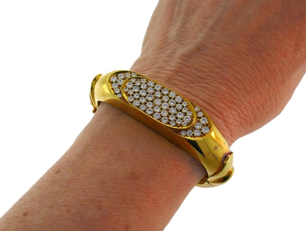 Bold and chic bangle bracelet created in the 1980s. 
Made of 18 karat (stamped) yellow gold and set with round brilliant cut diamonds (G-H color, VS1 clarity, approximately 2.40 carats total weight). 
Width 1/2 inch (1.3 cm). Fits up to 6.25-inch