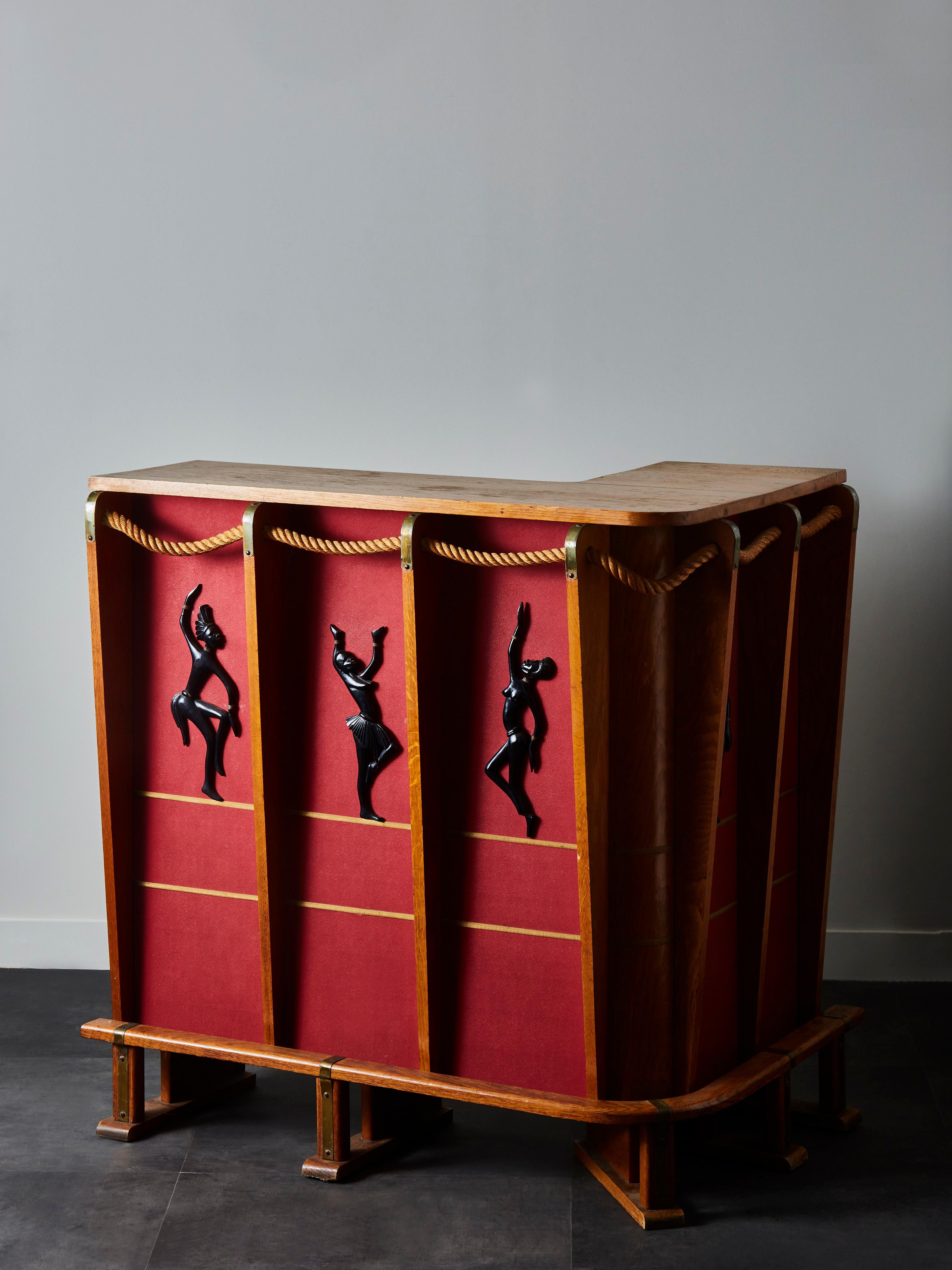 This bar by Audoux-Minet is made of oak and rope, five African dancers decorating each panel.