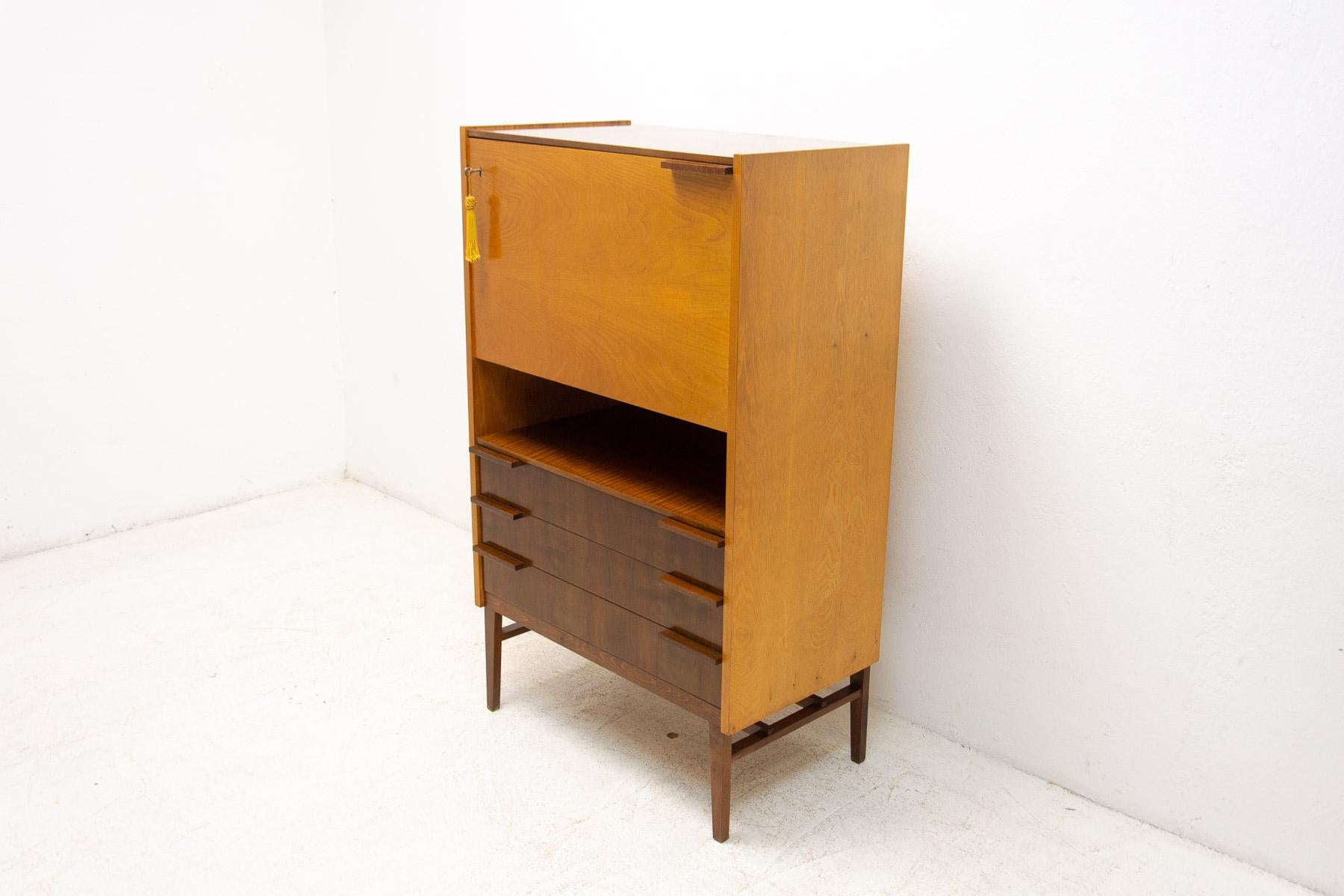 A bar cabinet with a hinged door at the top and three drawers at the bottom designed by the designer František Mezulánik and manufactured in the 1960s by the company ÚP Závody.
This piece is fully functional, including locking. In the upper part of