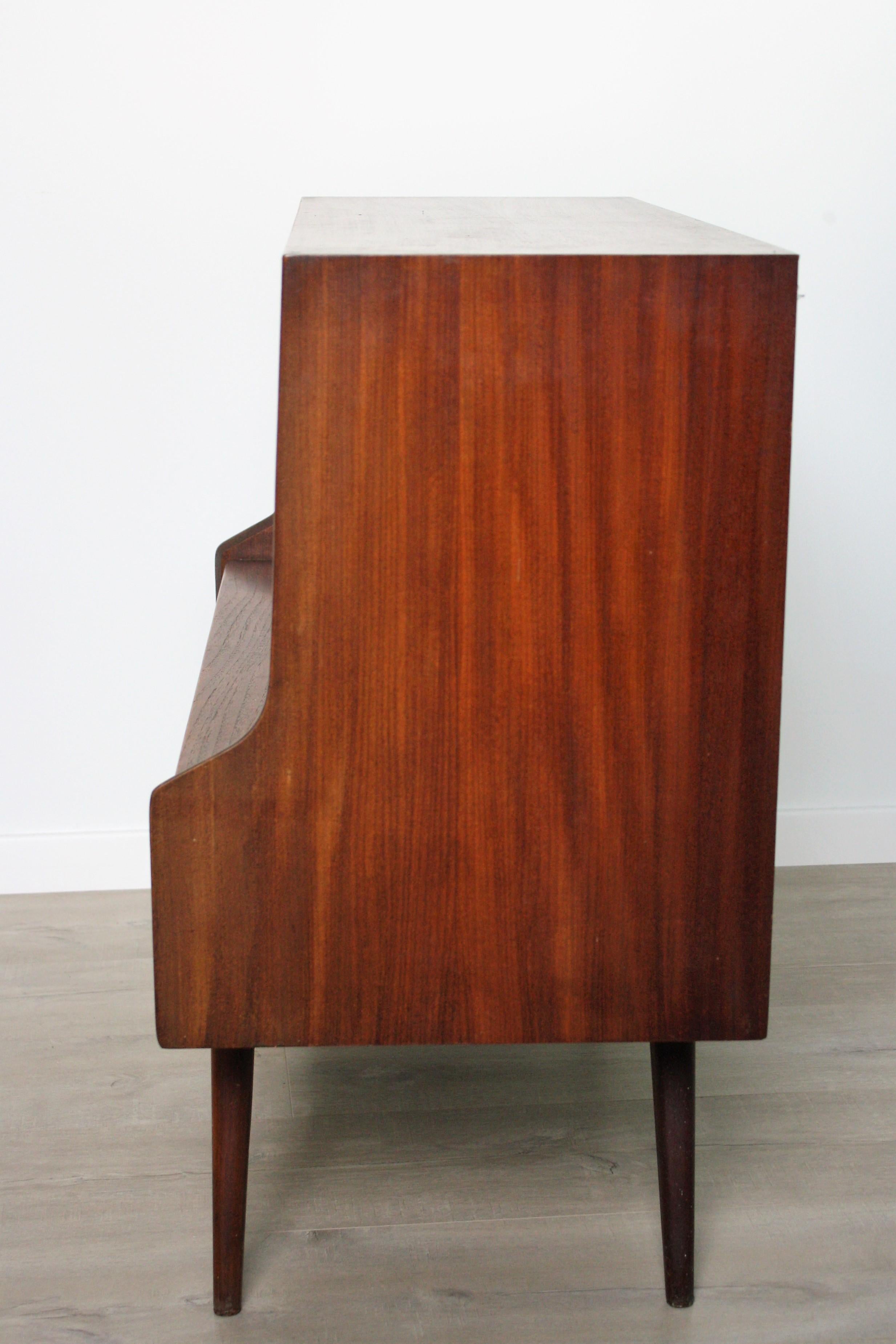 This teak liquor cabinet was designed by Louis van Teeffelen during the 1960s and was made by Wébé in the Netherlands. It features a compartment where bottles and glasses can be stored and has two drawers.

Beautiful design, very good
