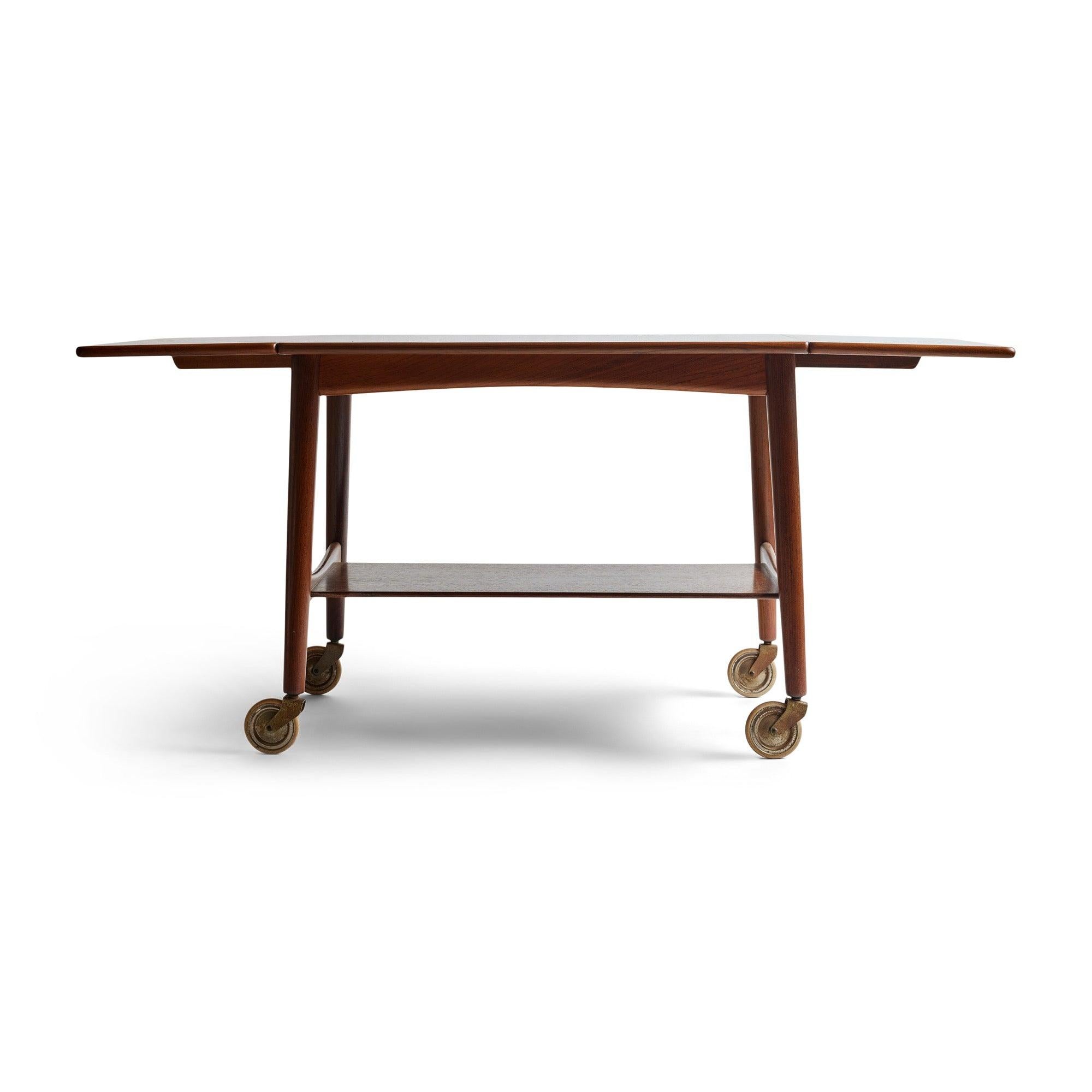 A drop leaf teak bar cart on casters.