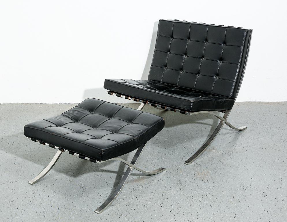 Vintage Barcelona lounge chairs set with ottoman designed by Ludwig Mies van der Rohe. 1950s Knoll production. Tufted black leather cushions over a swept steel bar frame. One seat cushion has been reupholstered. All pieces signed.