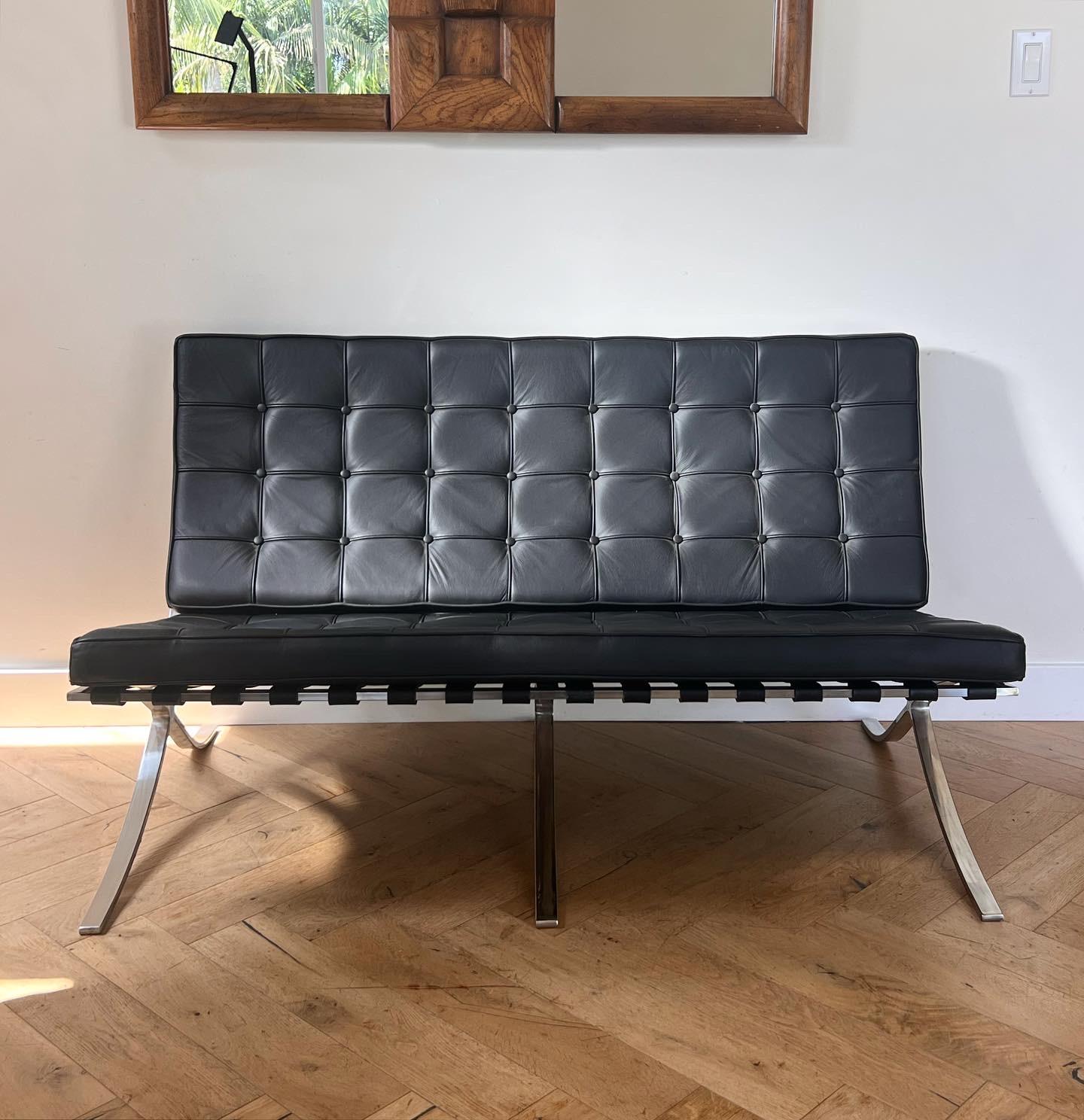 A very high-end 1980s replica of the iconic Barcelona sofa designed by Mies van der Rohe in the 1920s and later manufactured by Knoll. Featuring superb quality vegan leather in licorice black and a chrome base which recalls ancient Egyptian seating.