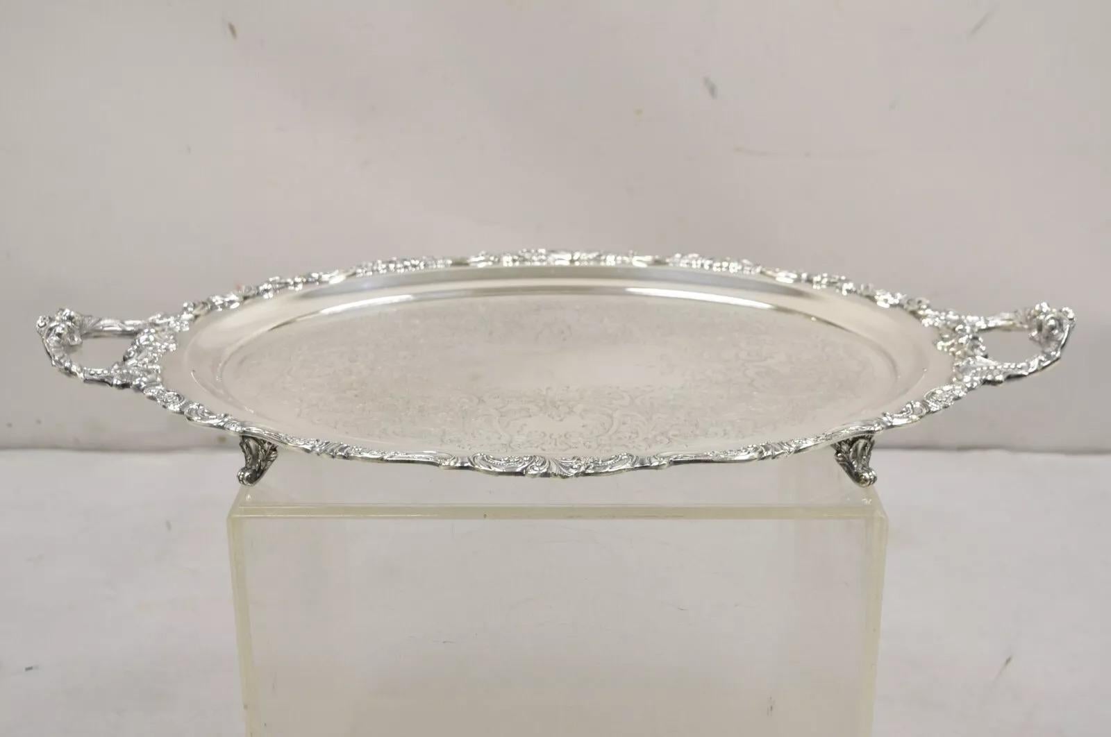 Vintage Baroque by Wallace 294F Oval Silver Plated Serving Platter Tray. Item features ornate twin handles, scrollwork etched center, raised on ornate feet, very nice vintage tray. Circa Mid 20th Century. Measurements: 2.5
