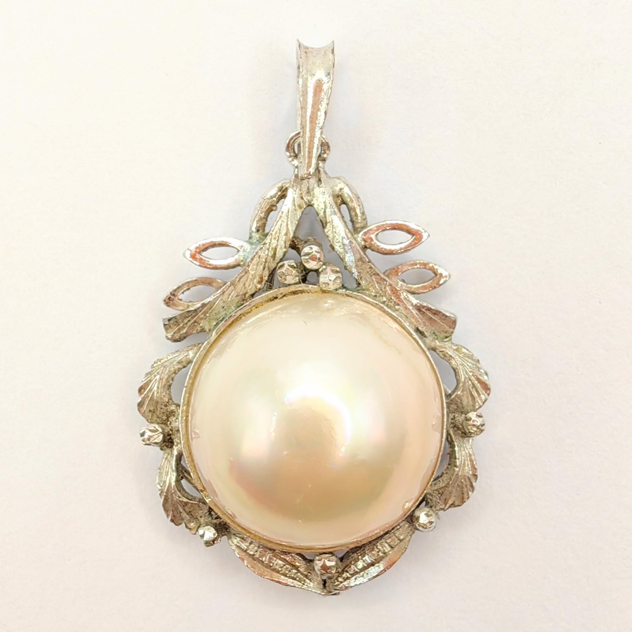 Introducing our Vintage Baroque Style 14mm Mabé Pearl Necklace Pendant in Sterling Silver, a stunning piece that showcases the timeless elegance of a lustrous Mabé Pearl in a unique and intricate design.

At the center of this pendant rests a