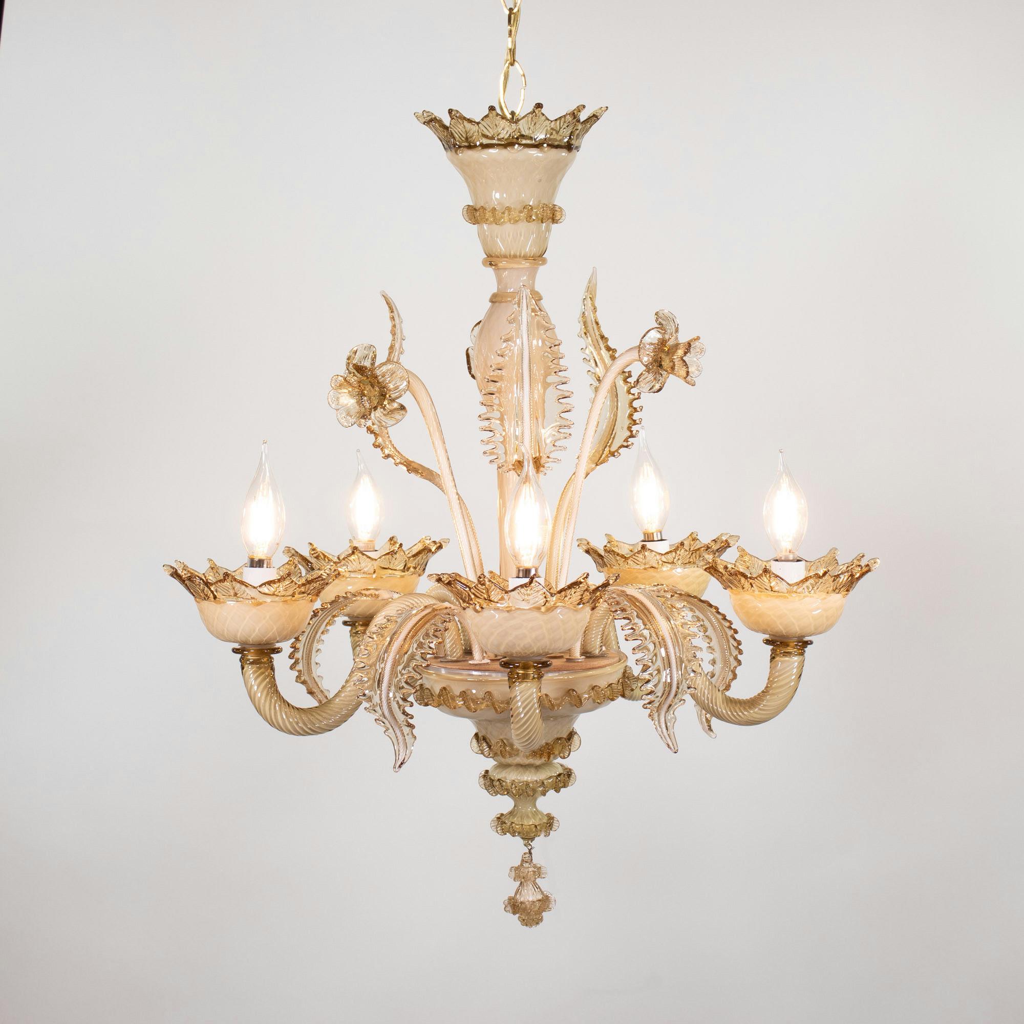 Questo squisito lampadario in vetro di Murano color latte e miele mette in mostra la maestria dell'artigianato del vetro veneziano. Presenta una colonna centrale a bulbo con dettagli di germogli, qui stilizzati con narcisi e foglie, e cinque bracci