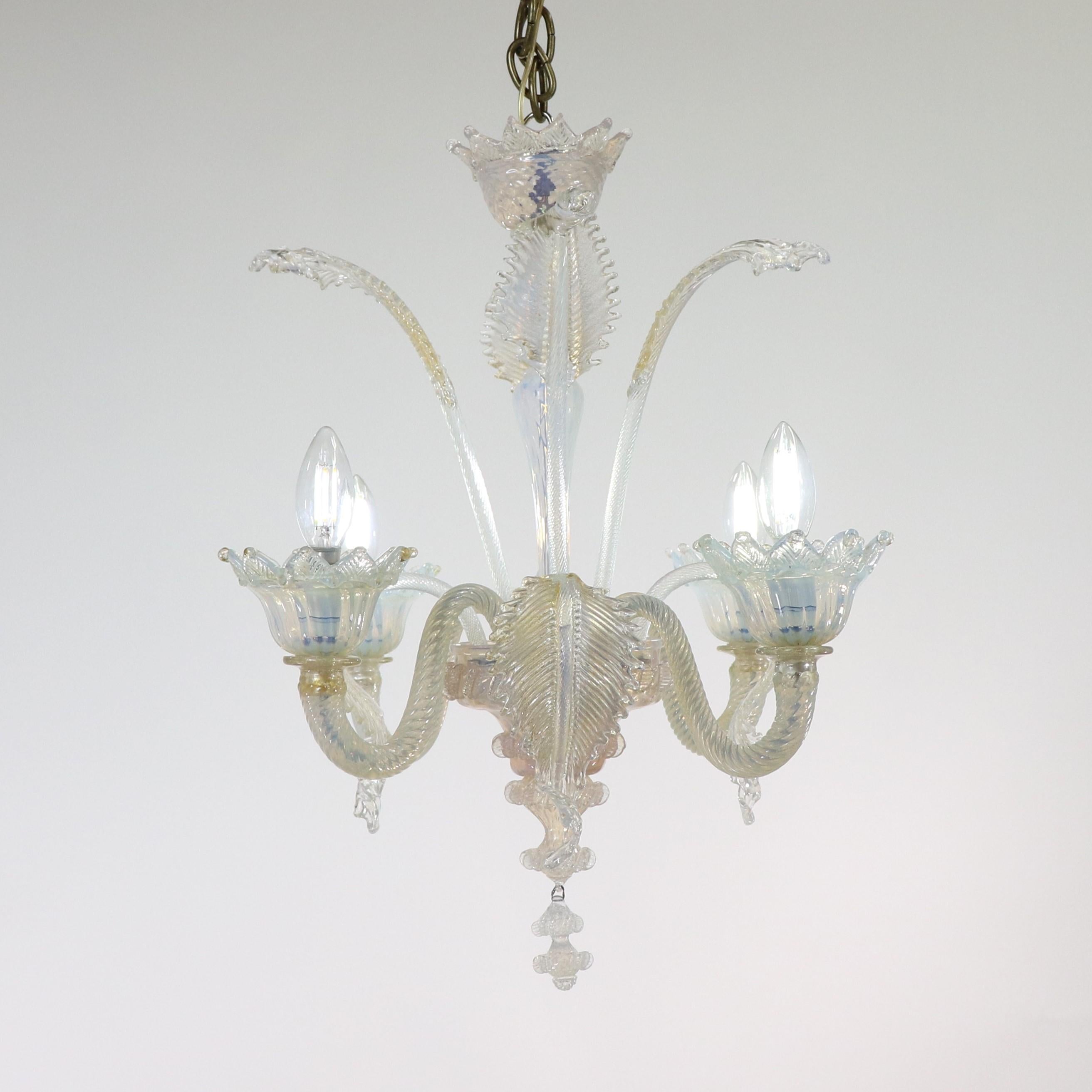 This gorgeous handcrafted gold-infused opaline Murano chandelier demonstrates a delicate Baroque-style design still loved by many. This piece has four flexing arms holding bobeches with petal-shaped trim. The milky opaline glass veers towards a