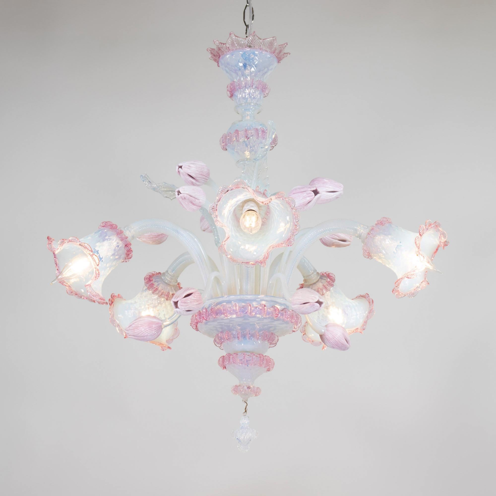 Questo splendido lampadario in stile barocco della metà del secolo scorso è meticolosamente realizzato a mano in squisito vetro di Murano rosa e opalino. Questo pezzo presenta cinque eleganti bracci a forma di voluta, ognuno dei quali è ornato da