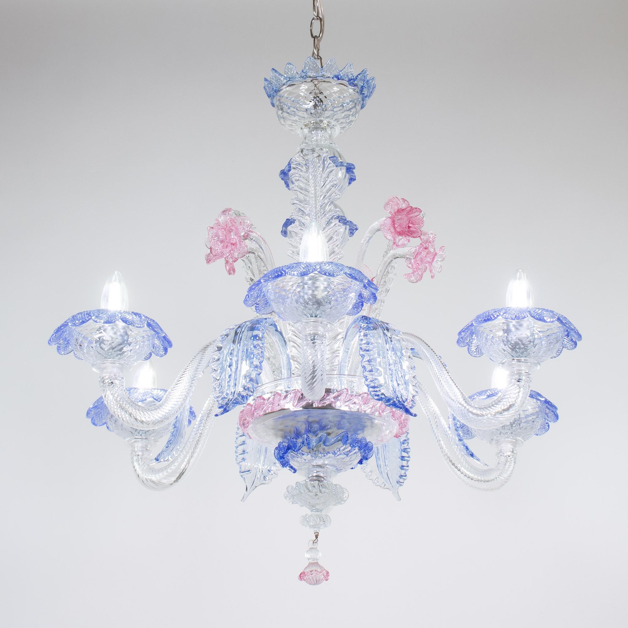 This exquisite Murano glass chandelier showcases a mastery of glass craftsmanship, made from clear cristallo glass with blue and pink adornments. Featuring a bulbous center column with sprouting details, stylized here with daffodils and leaves, and