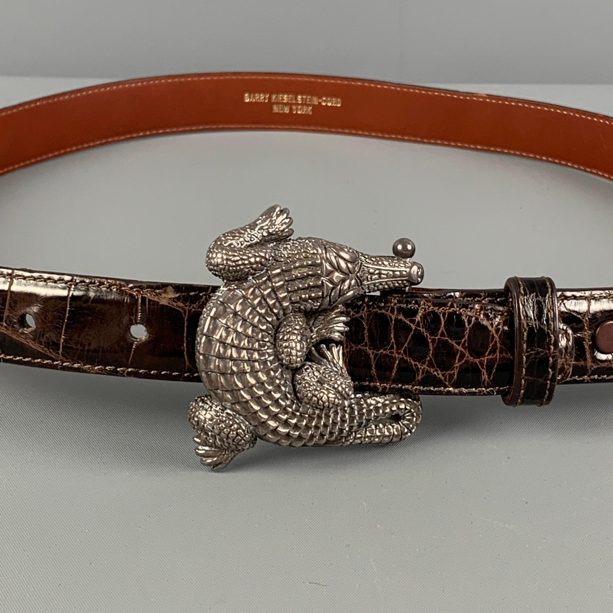 Vintage BARRY KIESELSTEIN-CORD 1995 belt comes in a brown alligator leather featuring a sterling silver alligator buckle. 

Very Good Pre-Owned Condition.
Marked: 2

Length: 35 in.
Width: 0.75 in.
Min Length: 28 in.
Max Length: 32 in.
Buckle Length: