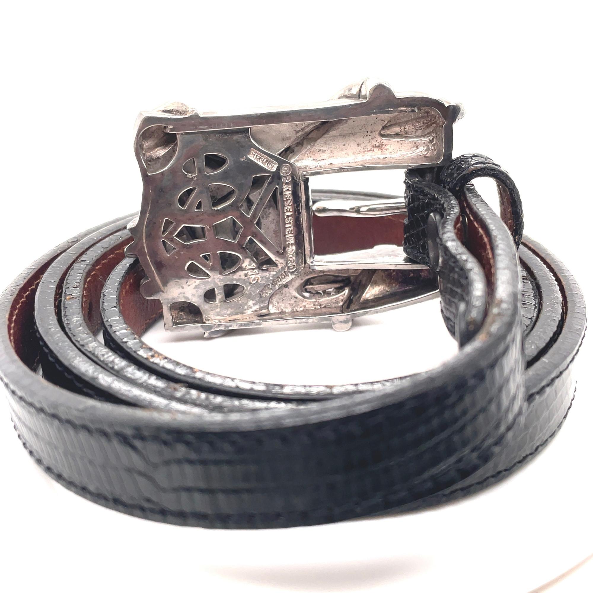 Vintage wide fancy buckle with a leather belt is one of Kieselstein-Cord's early and popular designs. This vintage wide fancy buckle with leaves design comes in silver tone hardware with a slim black leather belt. Buckle measurements: 2.5 inches x