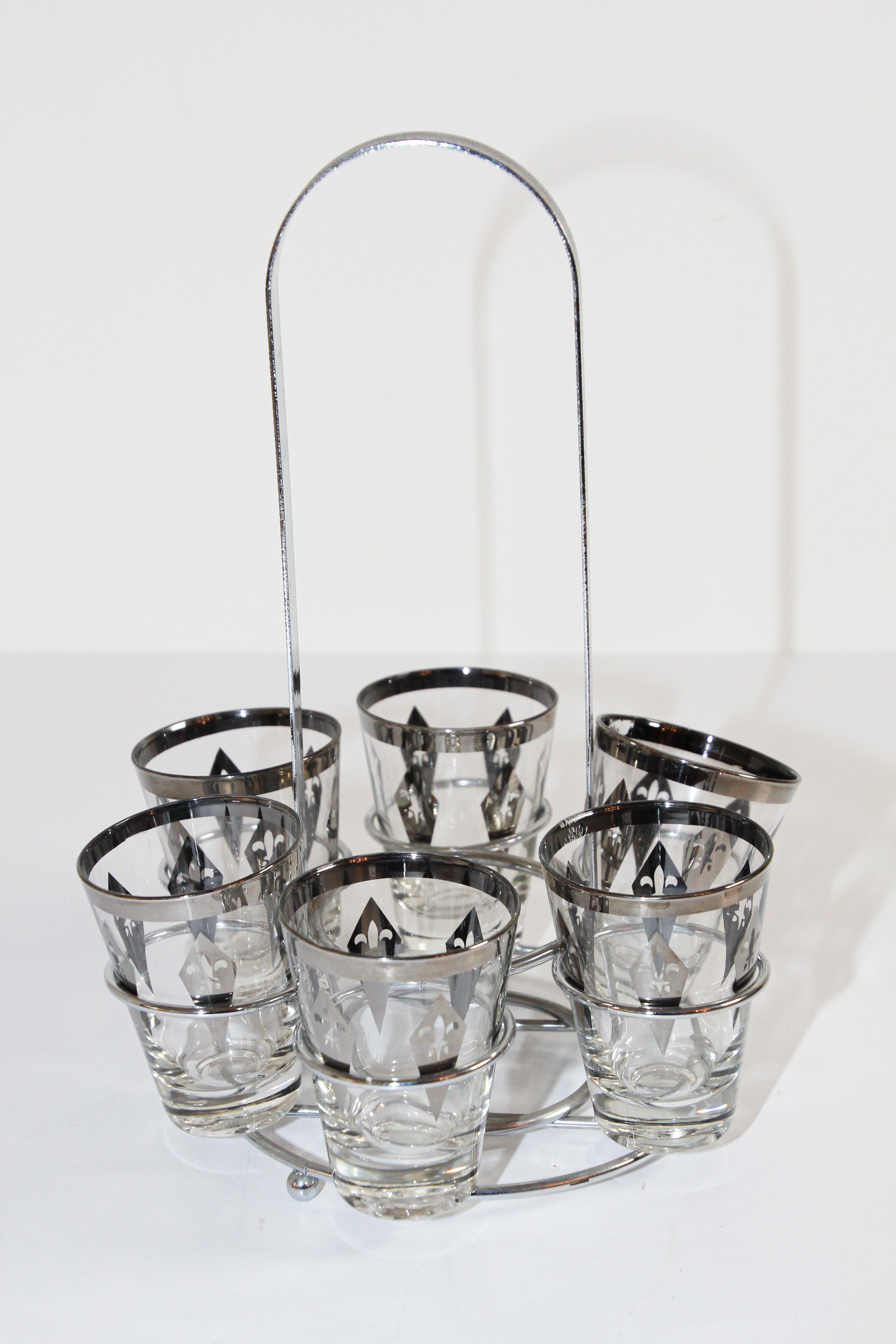 Elegant exquisite vintage set of six shot glasses designed with chrome carrying caddy.
The glasses are decorated with silver rimmed and a fleur-de-lys design.
Fantastic midcentury vintage glasses in excellent vintage condition.
Each glass