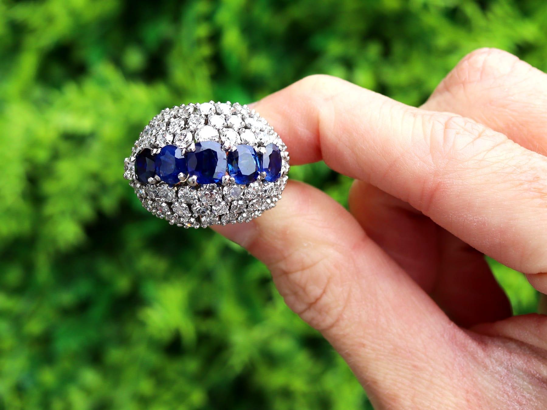 This stunning, fine and impressive vintage 1960s sapphire ring has been crafted in 18k white gold.

The substantial convex pierced decorated ring setting is ornamented with five round faceted cut Basaltic blue sapphires, totalling 5.17cts, all