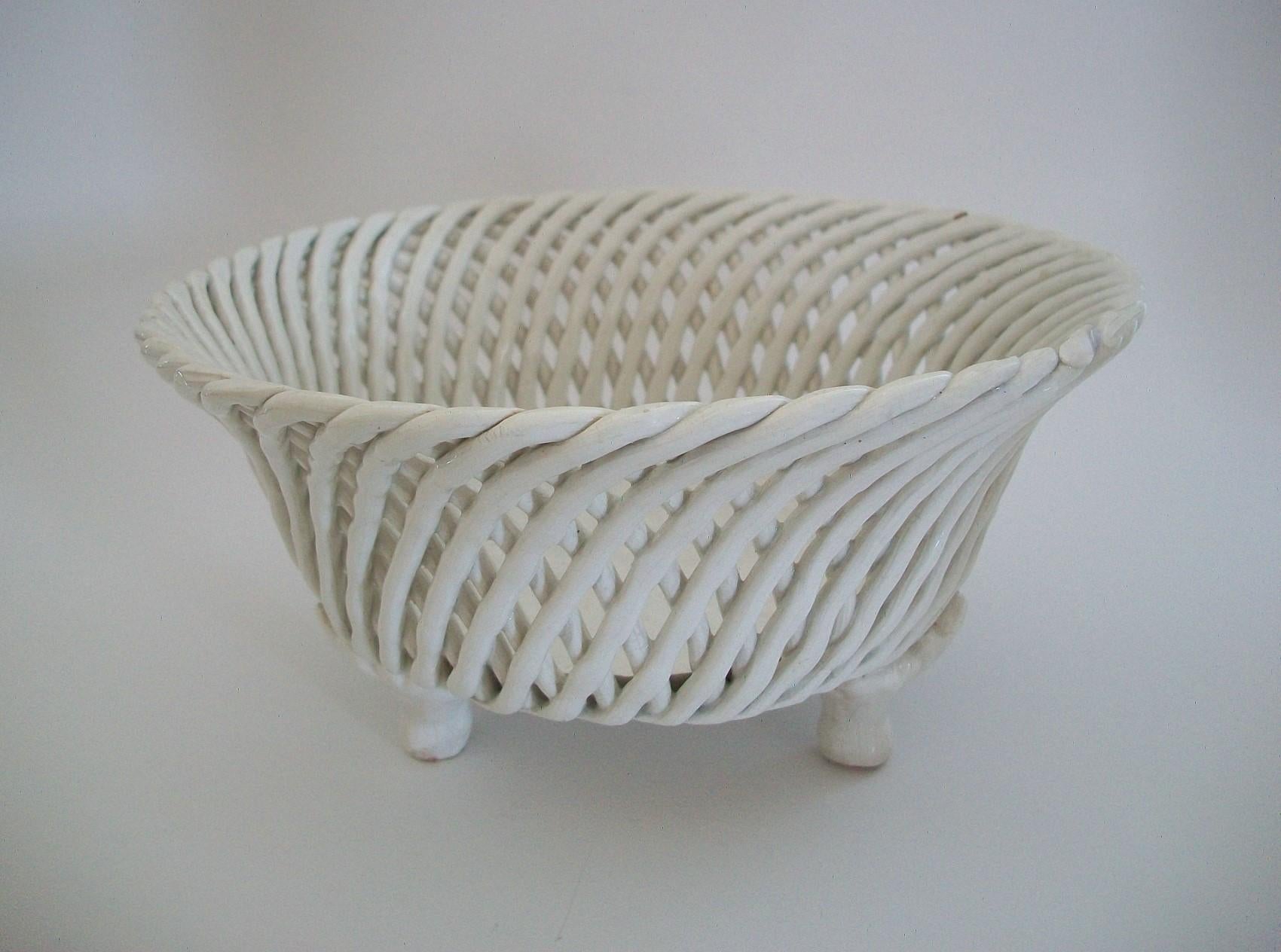 Vintage basket weave ceramic bowl - featuring a white ceramic body with an over-all clear glaze - raised on three feet with acanthus leaf decoration - unsigned - Europe - mid 20th century.

Good vintage condition - one edge chip (as photographed)