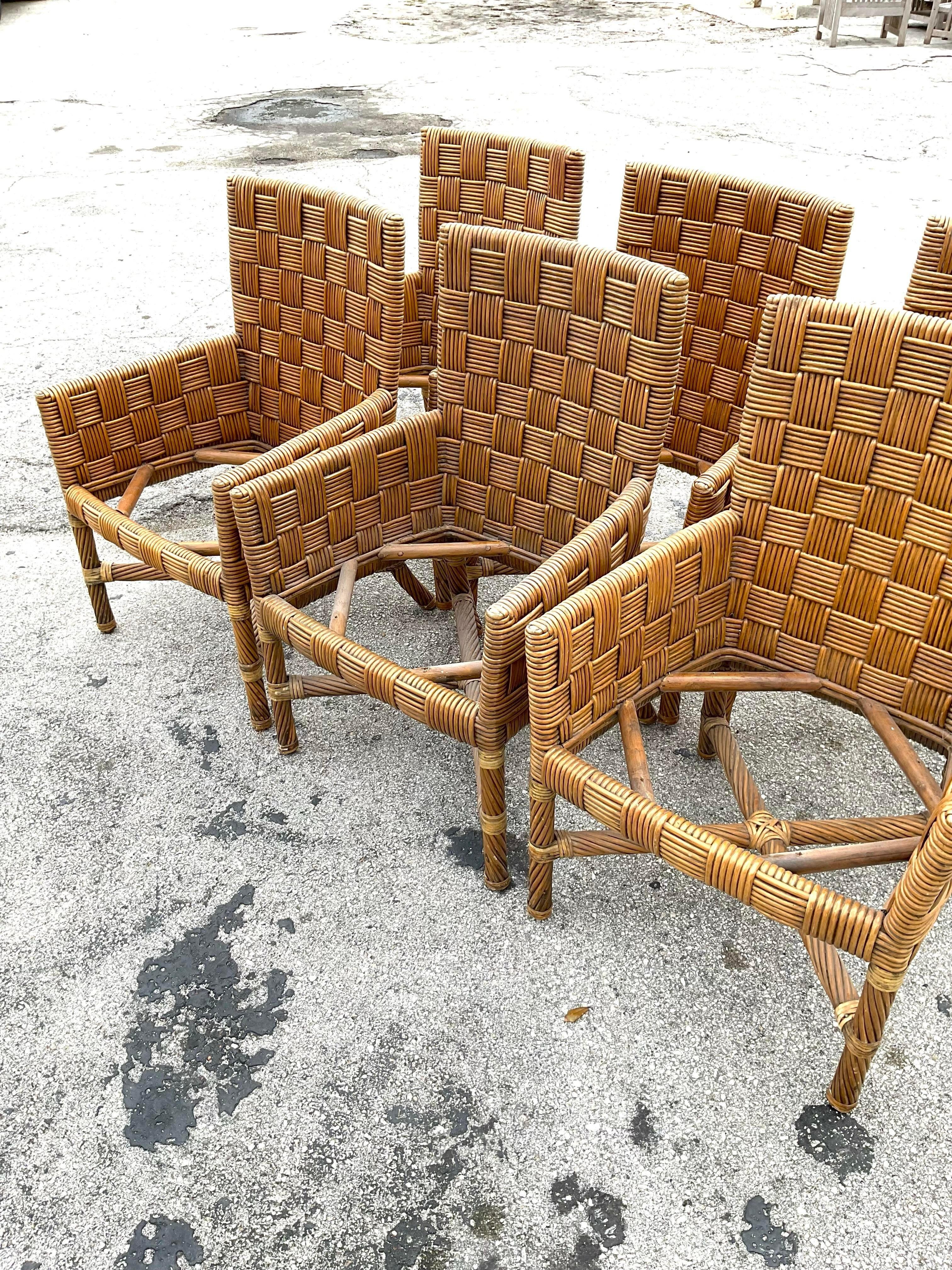 Vintage set de 6 fauteuils en rotin épais tressé en forme de panier. Un élément naturel fabuleux à ajouter à tout espace de repas. Tous les fauteuils sont munis d'accoudoirs, ce qui les rend confortables et élégants. Acquis d'une propriété de Palm