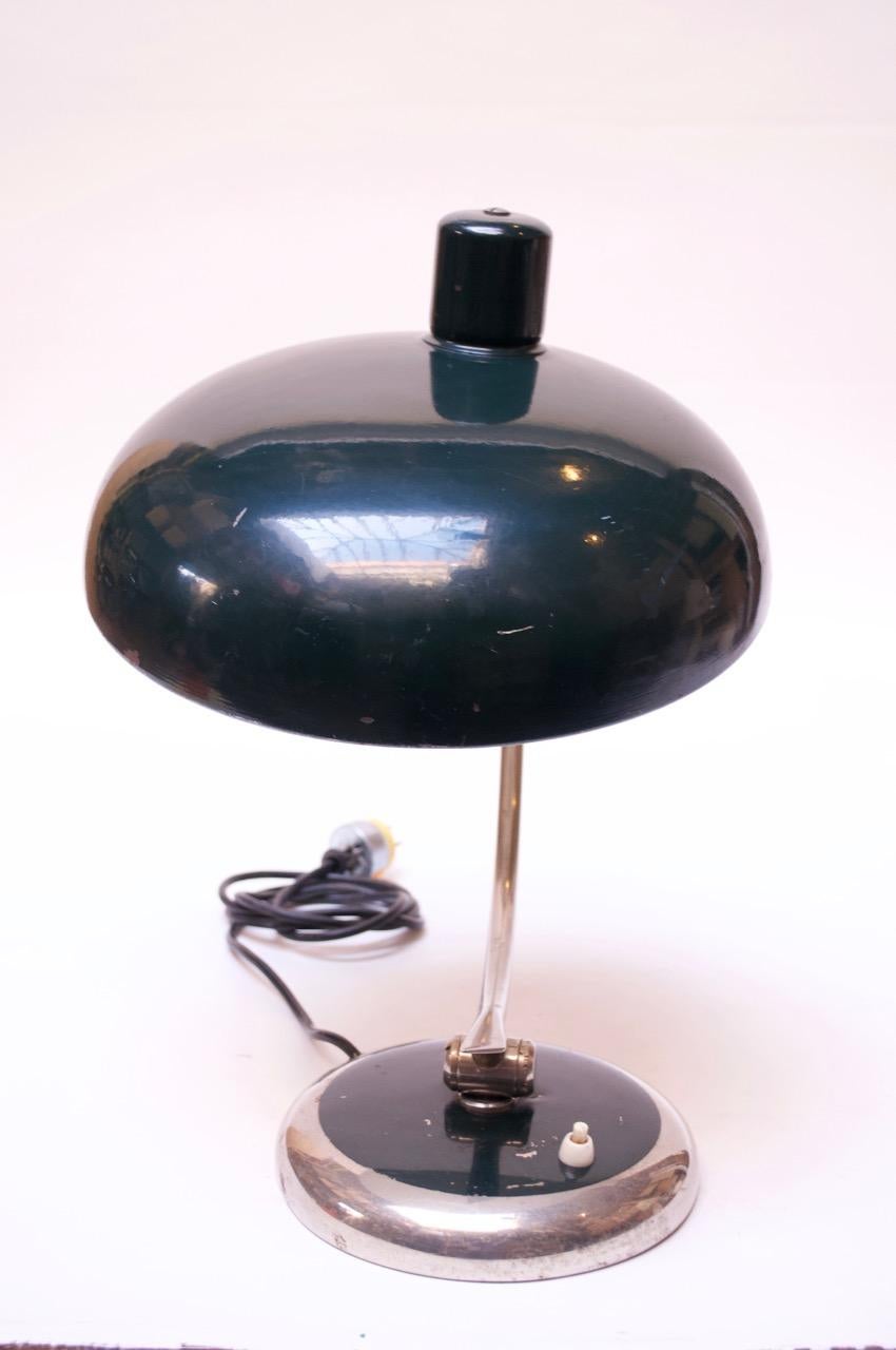 German industrial / Bauhaus- style table lamp in green enameled-metal and chrome, circa 1930s. Shade offers full 360 degree rotation as well as upward / downward movement.
Scratches / slight losses to the shade and heavier paint loss to the base.