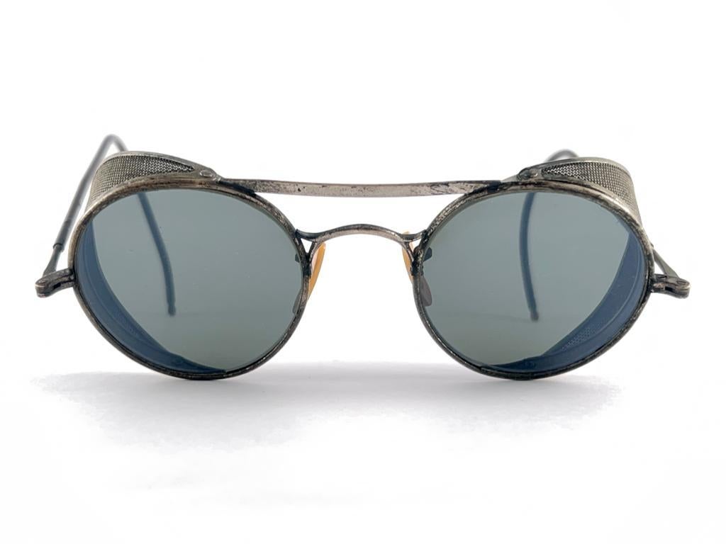 Superb Item!  
1950'S Bausch & Lomb Safety Goggles. Folding Silver Metal Side Cups And Special Wrapped Temples. Mint True Green Round Lenses.  
A Beautiful Piece Of Sunglasses History.


Made In Usa


Front                                           
