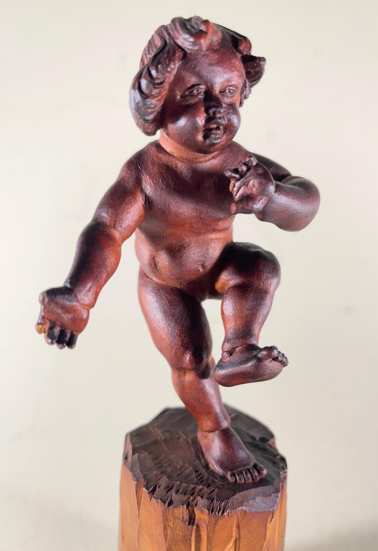 Vintage Bavarian wood carving of the infant bacchus

Oberammergau is a world-famous wood carver town in Bavaria, Germany. Nikolaus Lang, a known artist, created a small sculpture of a young Bacchus. The carving is masterfully done with perfect