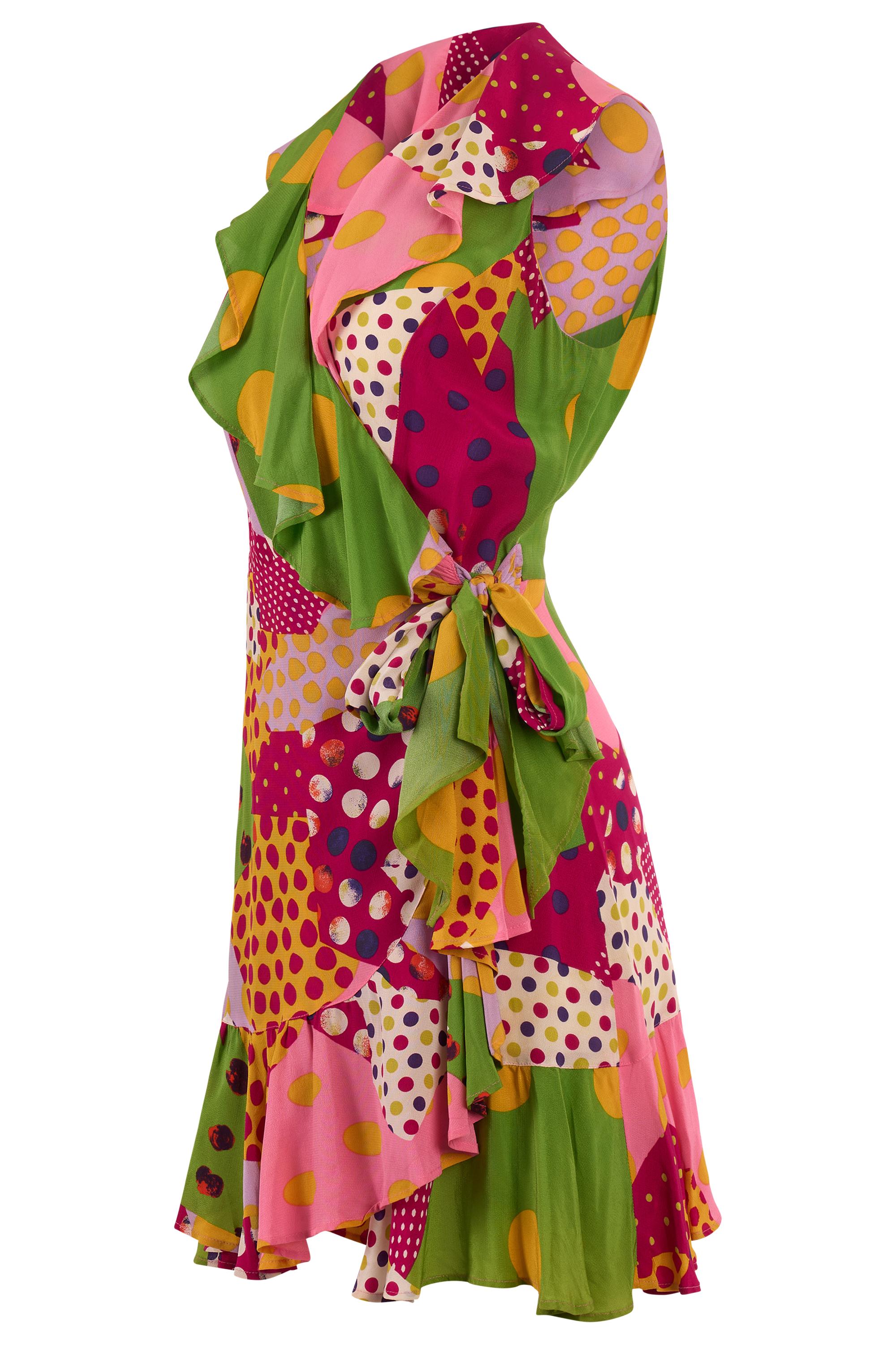 Vintage Bazar by Christian Lacroix gepunktetes Minikleid in Wickeloptik. Mit einem Patchwork-Punktdruck in verschiedenen Größen und Farben. Asymmetrische Rüschen an der Rückseite des Kragens, am Dekolleté und am Saum. Wird mit einem Band an der