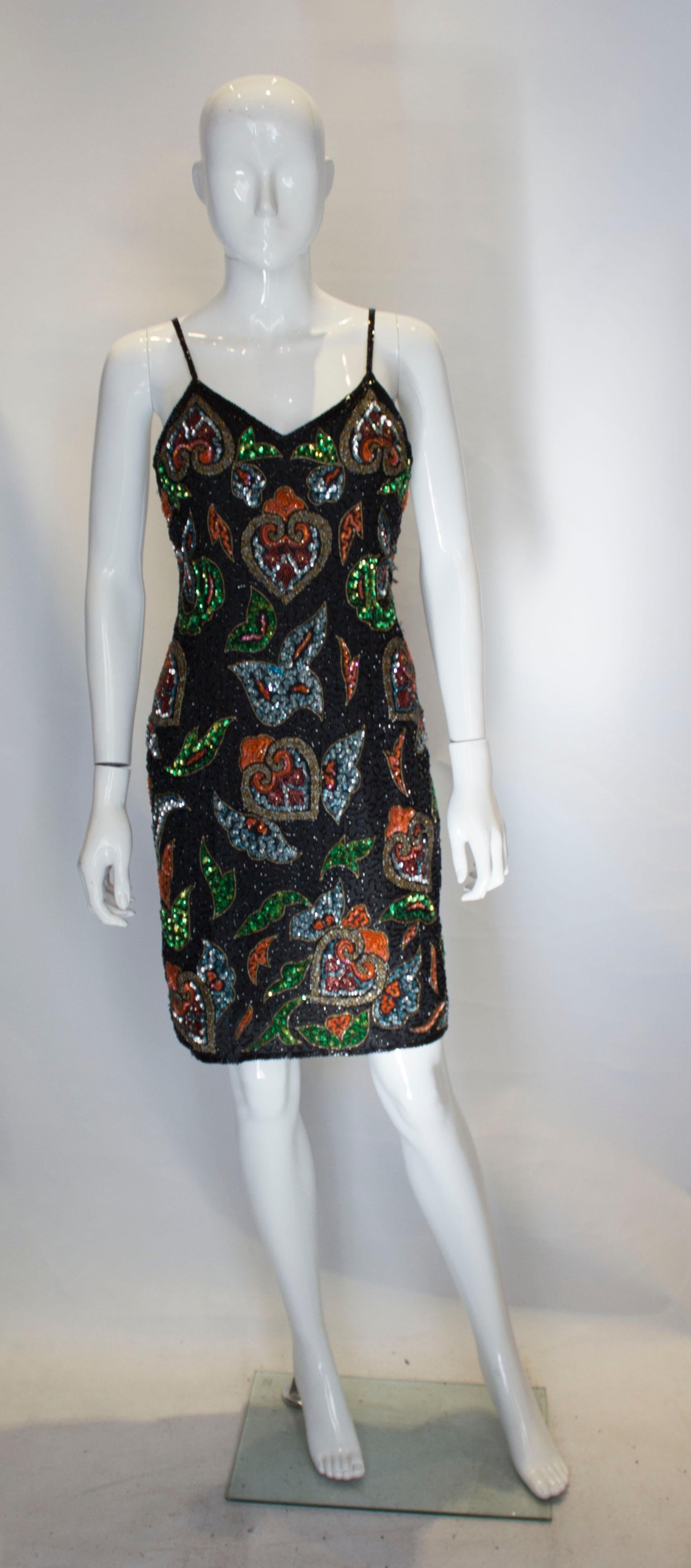 A chic vintage cocktails dress by Party Time. The dress has a black background with beading in a wonderful mix of Fall colours. The dress is fully lined , and has a central back zip. The dress has a 6 1/2 '' slit at the back.