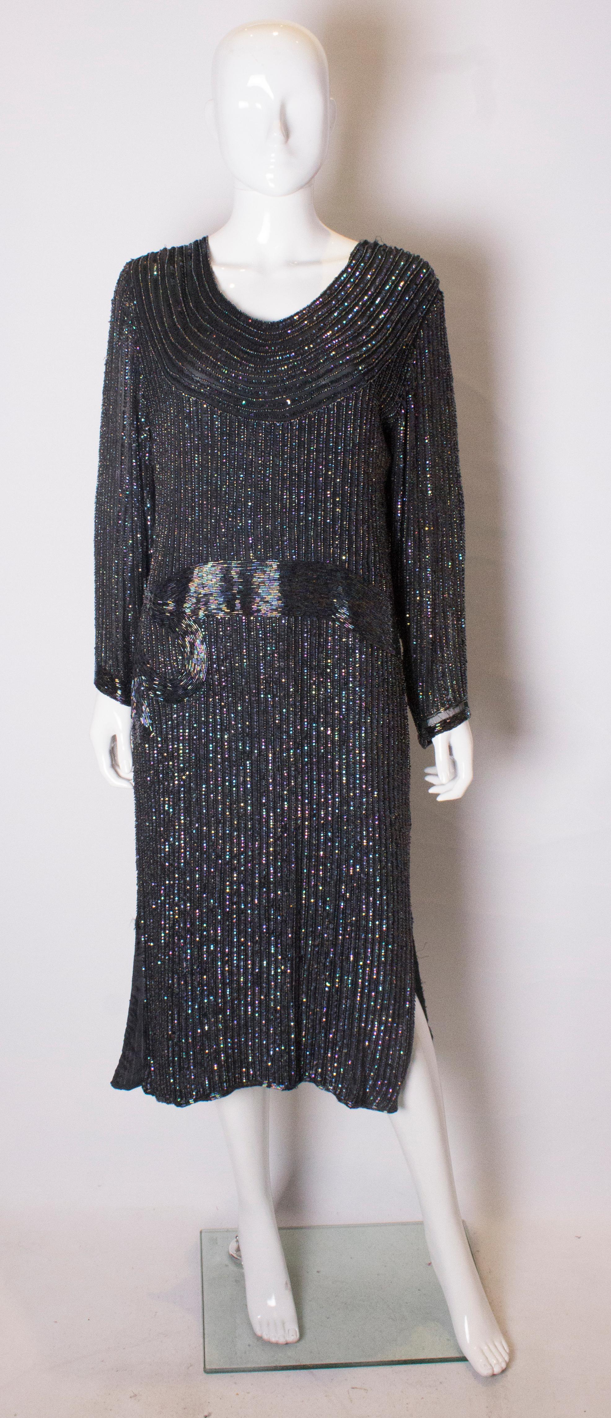 A chic beaded evening dress in an attractive blue/purple colour.  The dress is in silk with a scoop neckline with bead detail at waist leval.  It has an 11 '' slit on either side.