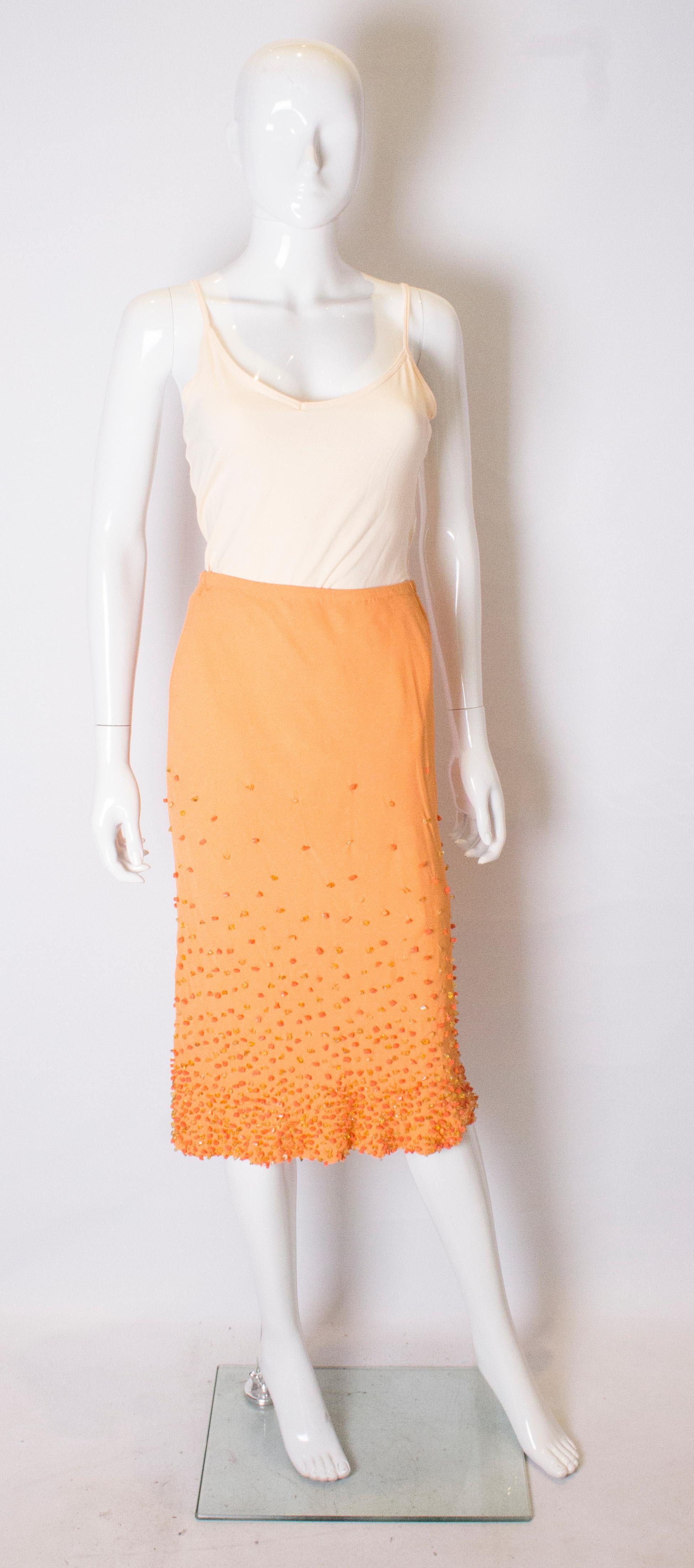 A cheerful skirt in orange crepe with wonderful orange and lemon colour beading on the lower section. The skirt has an elasticated waist (26'' -30'') and is fully lined. 