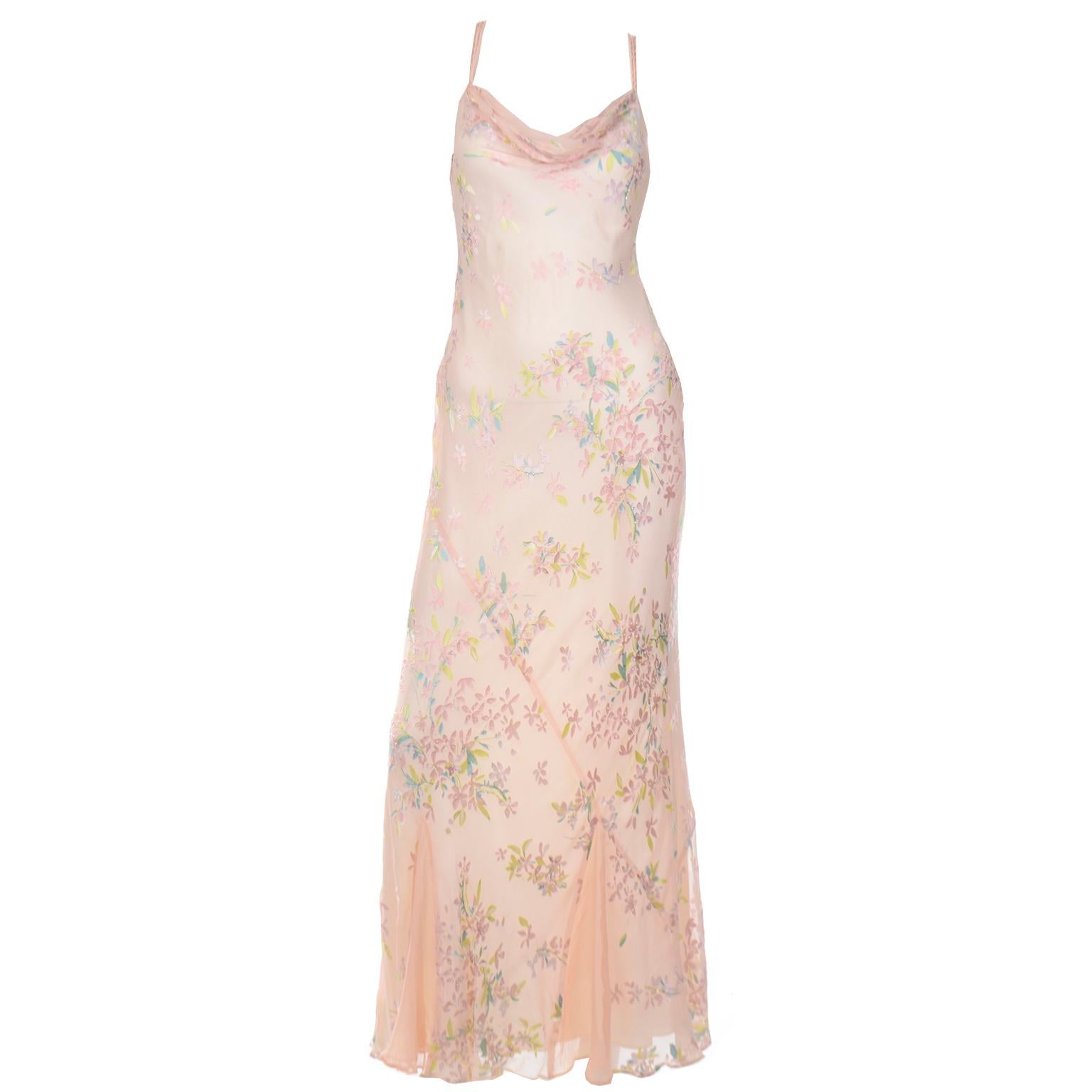 This is a 1930's inspired vintage 1990's evening dress that is cut on the bias and embellished with sequins and beads and a satin floral appliques in pastel shades..The dress is fully lined in taffeta and has triple beaded narrow straps that are