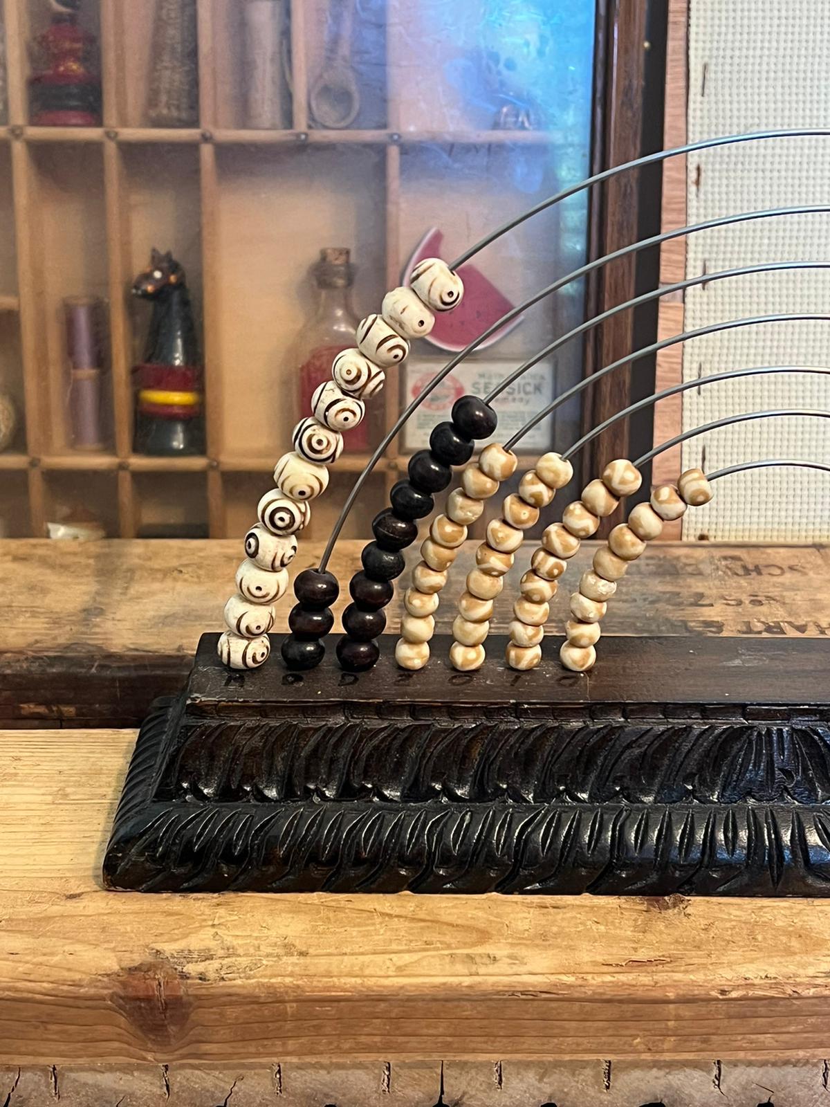A Carved wooden base with Seven arced rods in the shape of a rainbow with beautifully designed beads of counting or Calendar. Good Vintage Condition.

Dimensions. 12 W ; 3 D ; 7 H